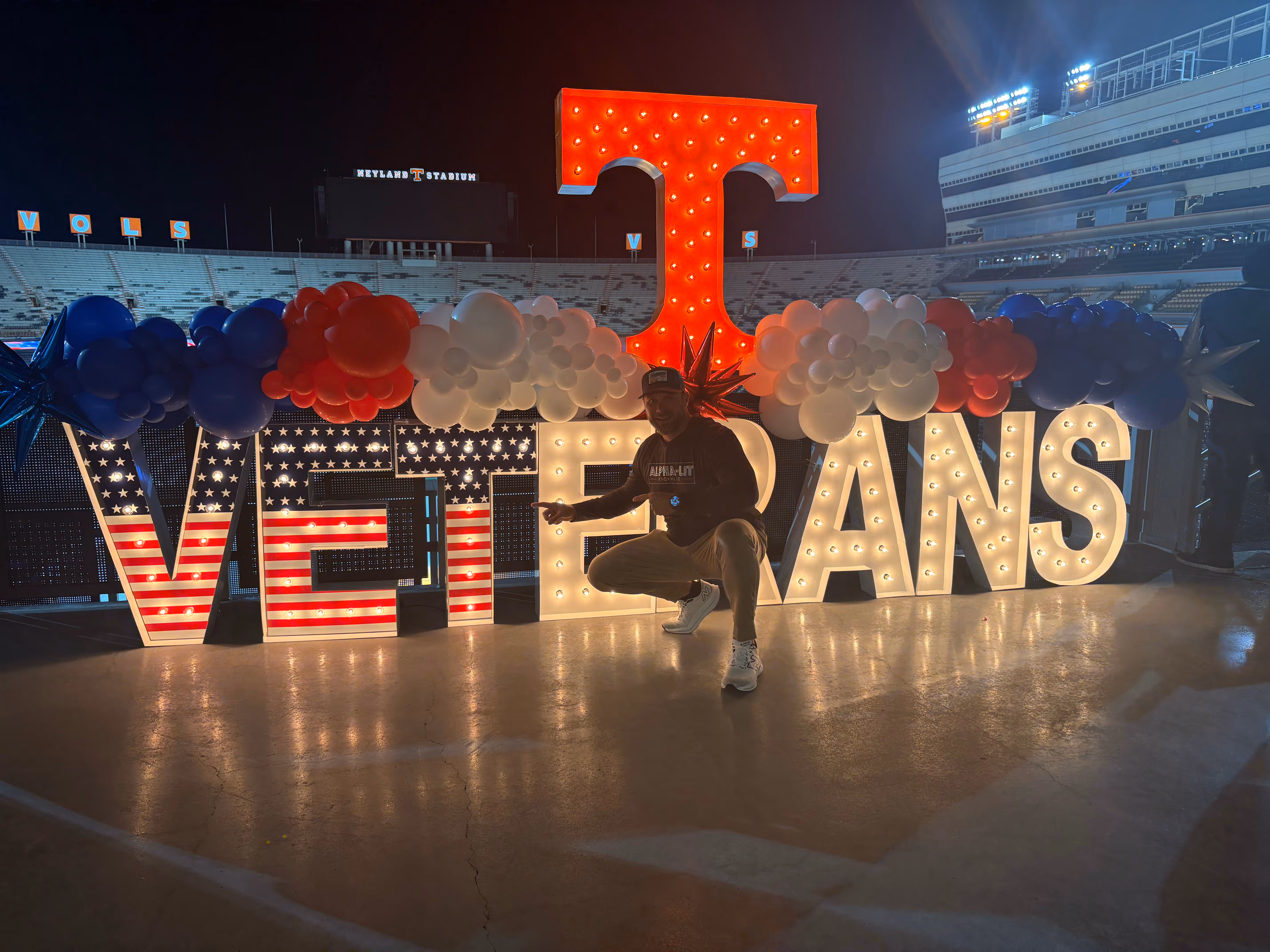 Lit letters spelling HVMS in front of silver and blue balloons at Hardin Valley Middle School with mural stars and music notes on the wall.