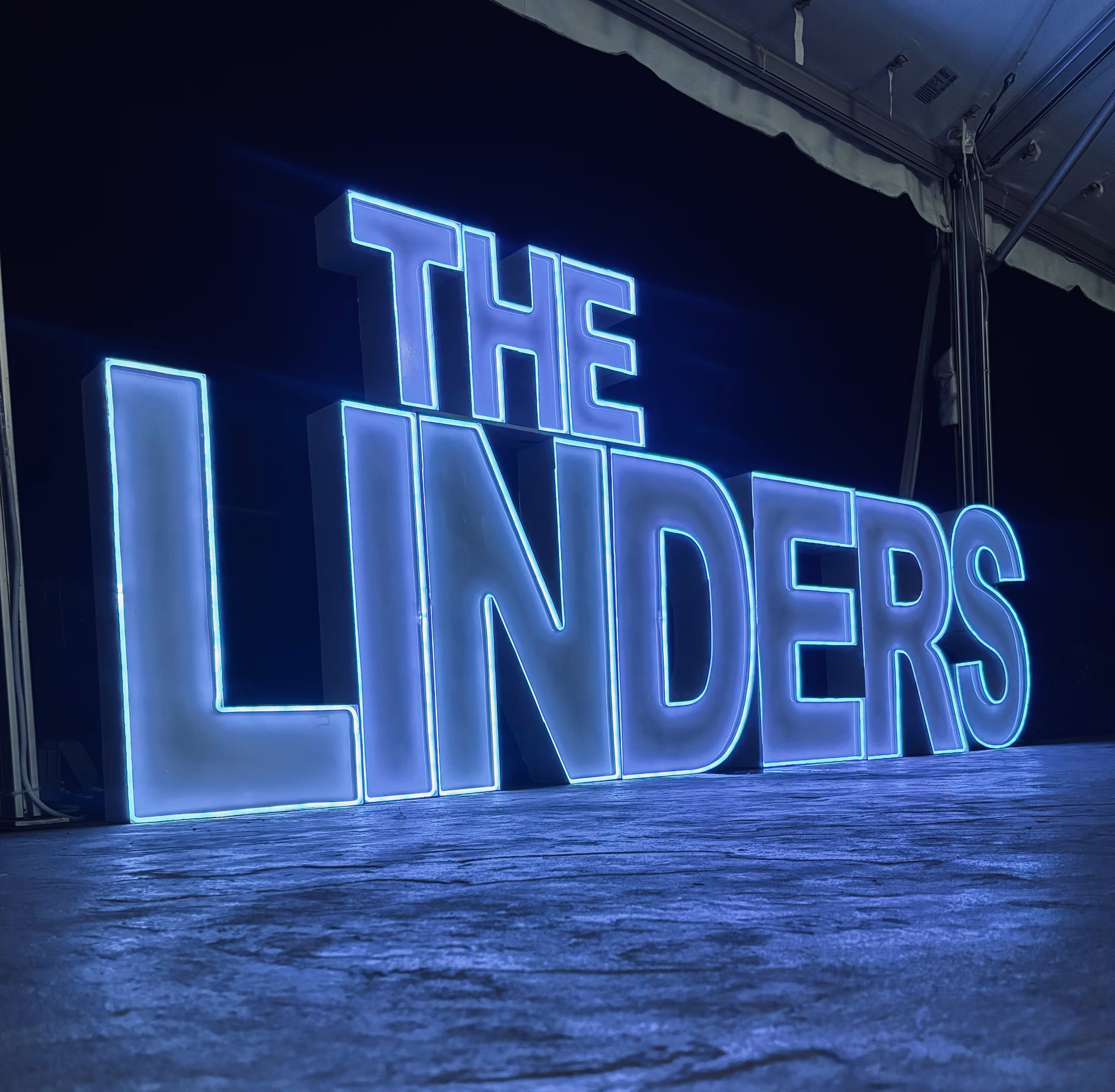 Lit letters spelling HVMS in front of silver and blue balloons at Hardin Valley Middle School with mural stars and music notes on the wall.