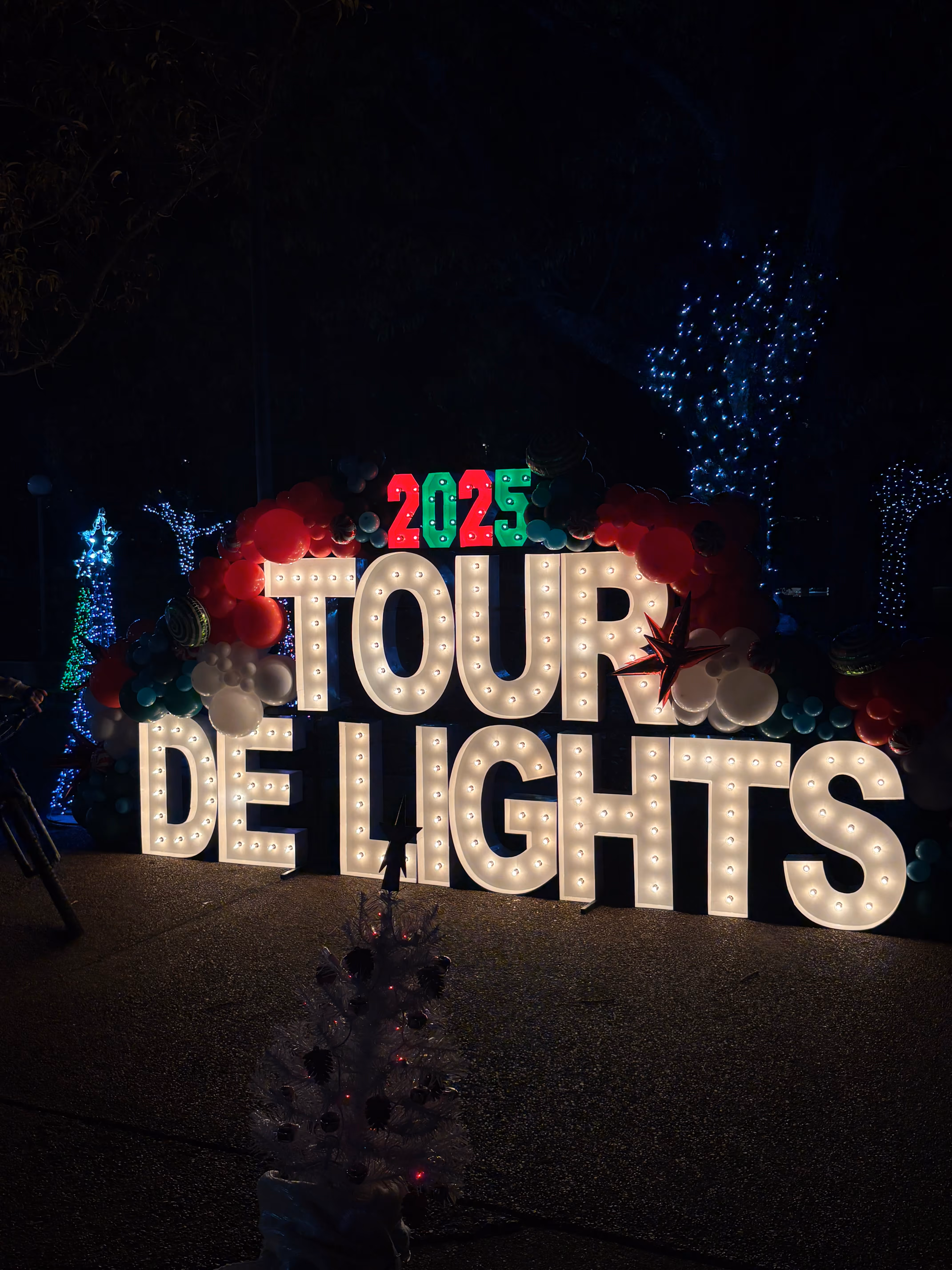 Lit letters spelling HVMS in front of silver and blue balloons at Hardin Valley Middle School with mural stars and music notes on the wall.