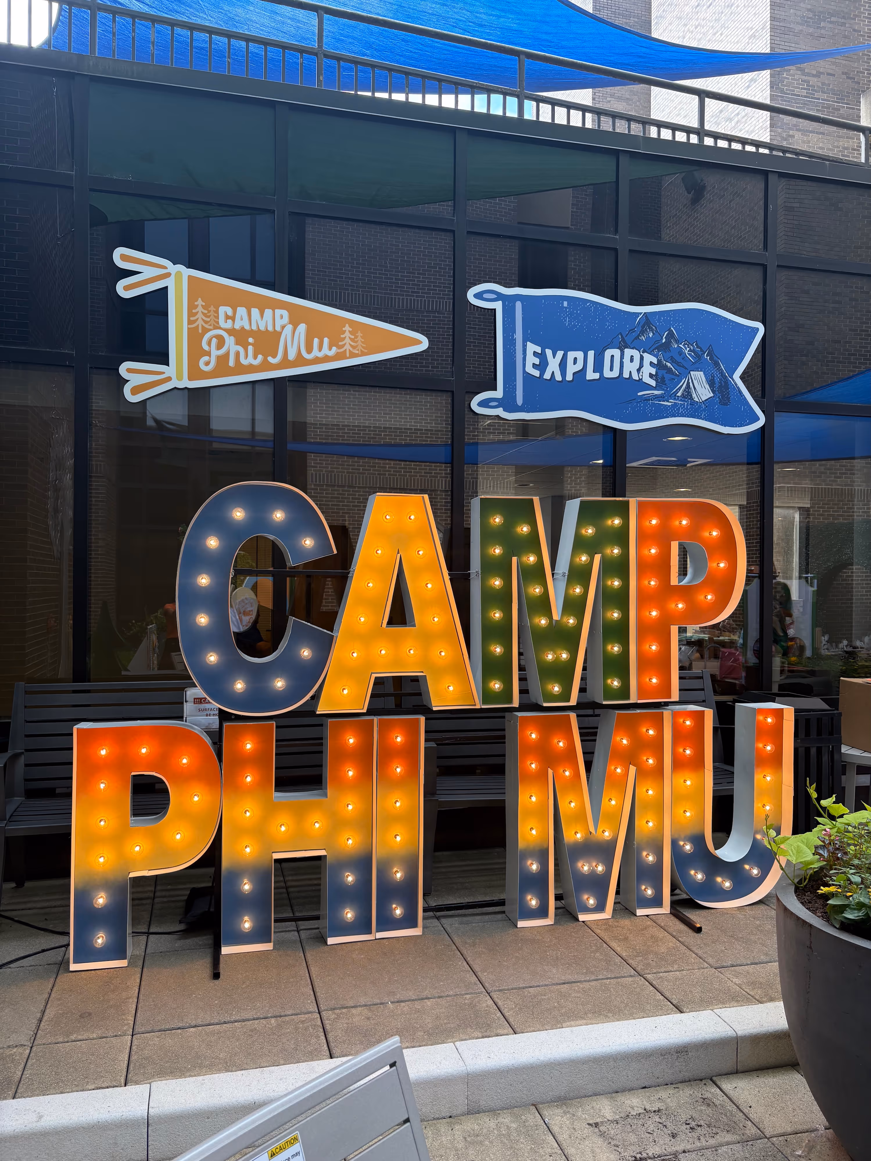 Lit letters spelling HVMS in front of silver and blue balloons at Hardin Valley Middle School with mural stars and music notes on the wall.