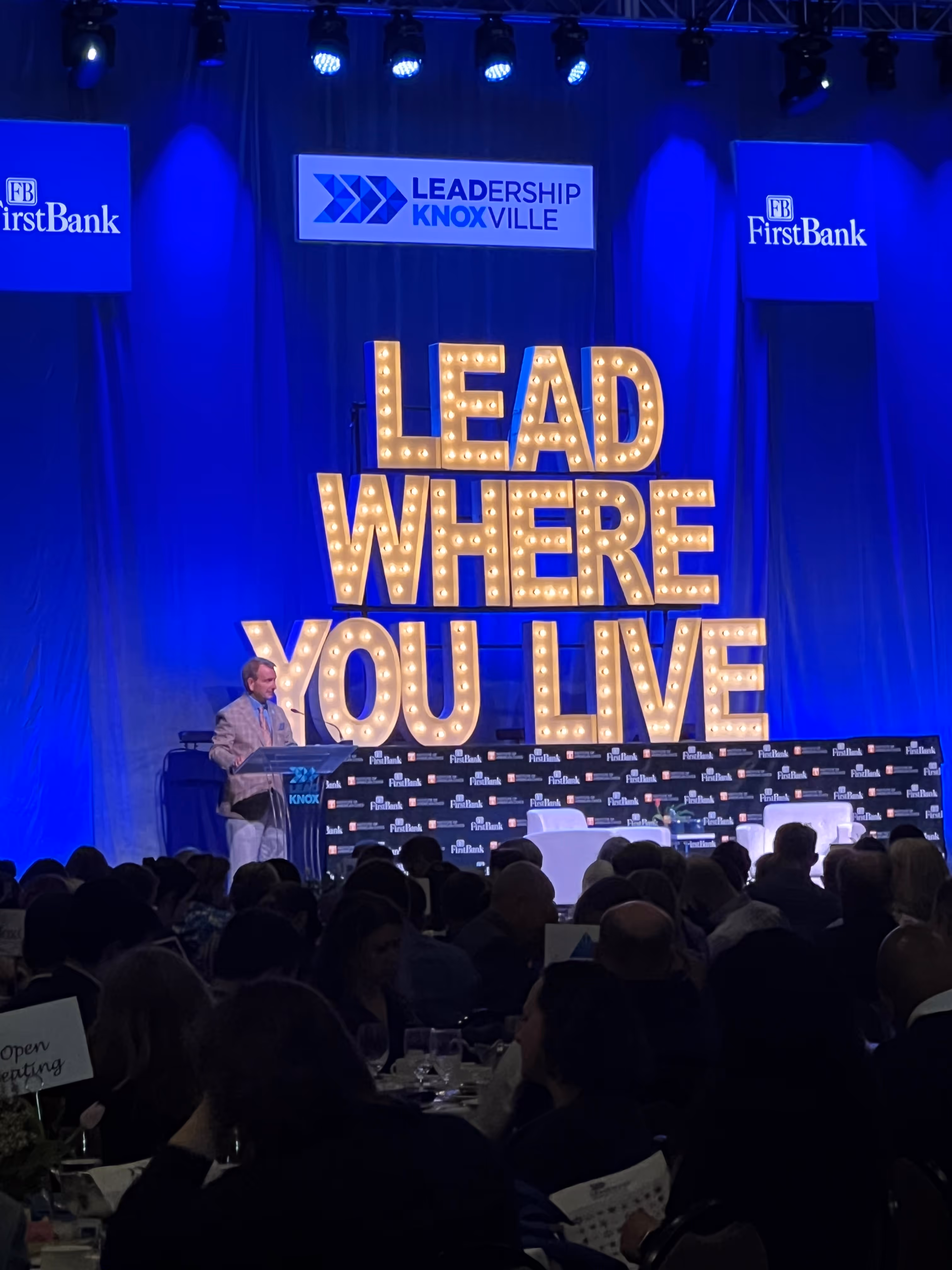 Lit letters spelling HVMS in front of silver and blue balloons at Hardin Valley Middle School with mural stars and music notes on the wall.