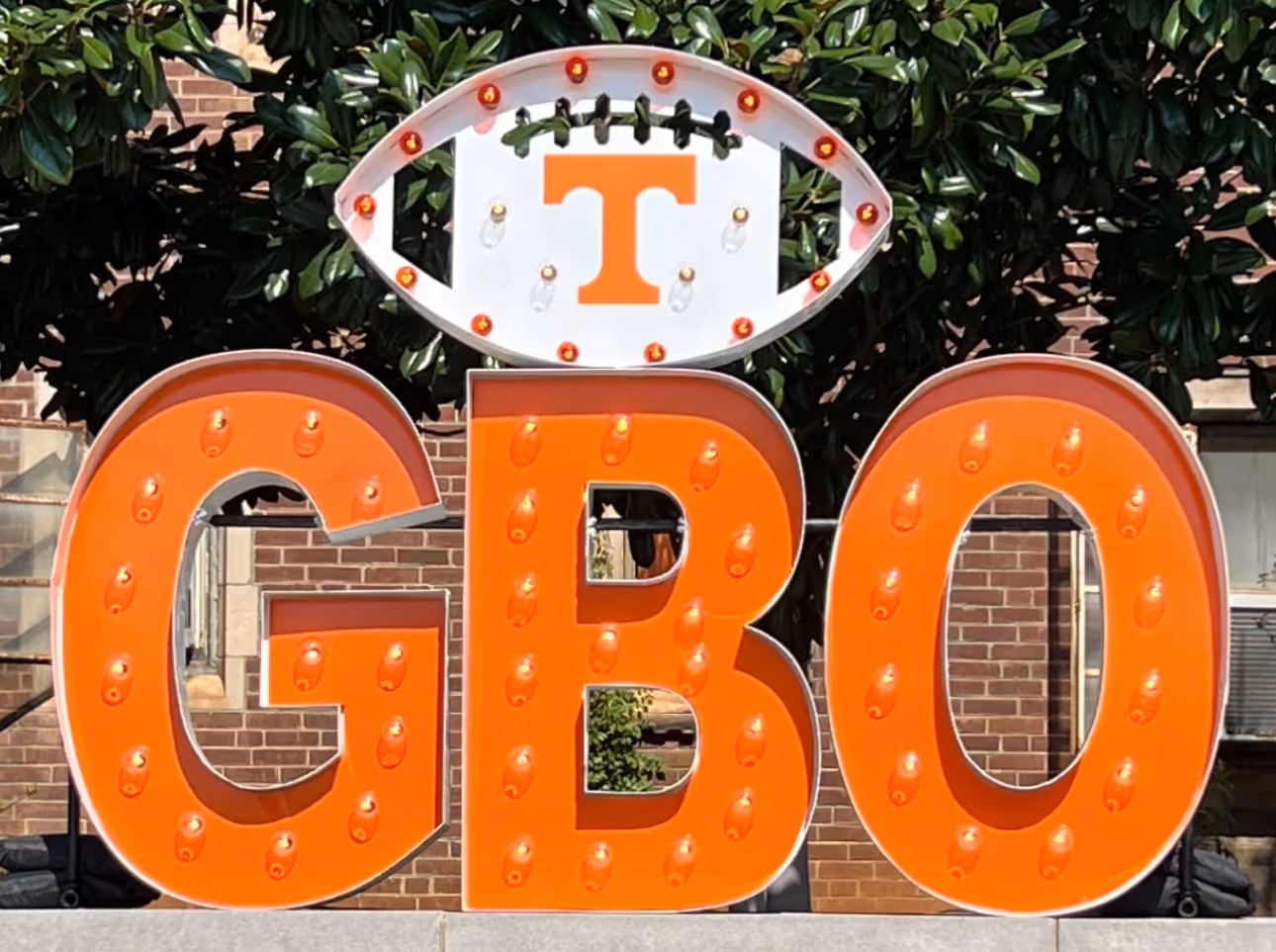 Lit letters spelling HVMS in front of silver and blue balloons at Hardin Valley Middle School with mural stars and music notes on the wall.