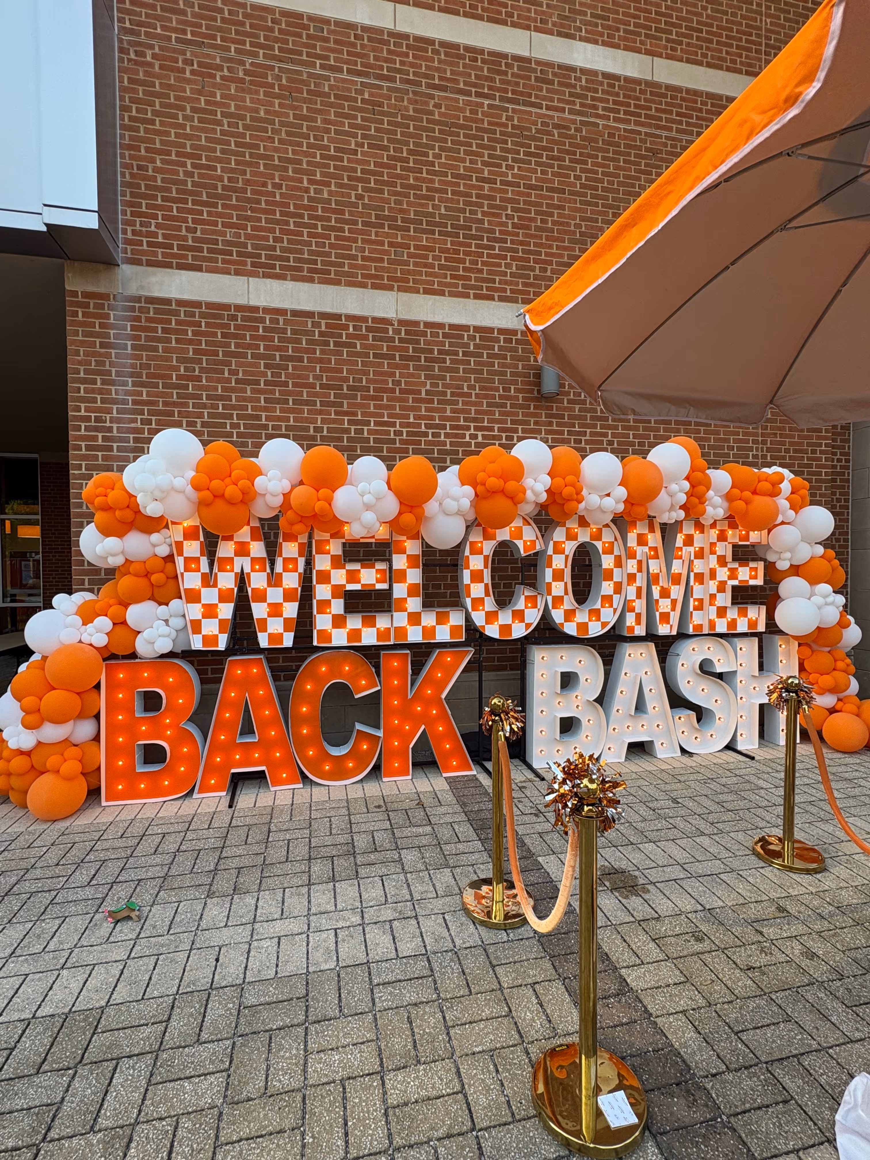 Lit letters spelling HVMS in front of silver and blue balloons at Hardin Valley Middle School with mural stars and music notes on the wall.