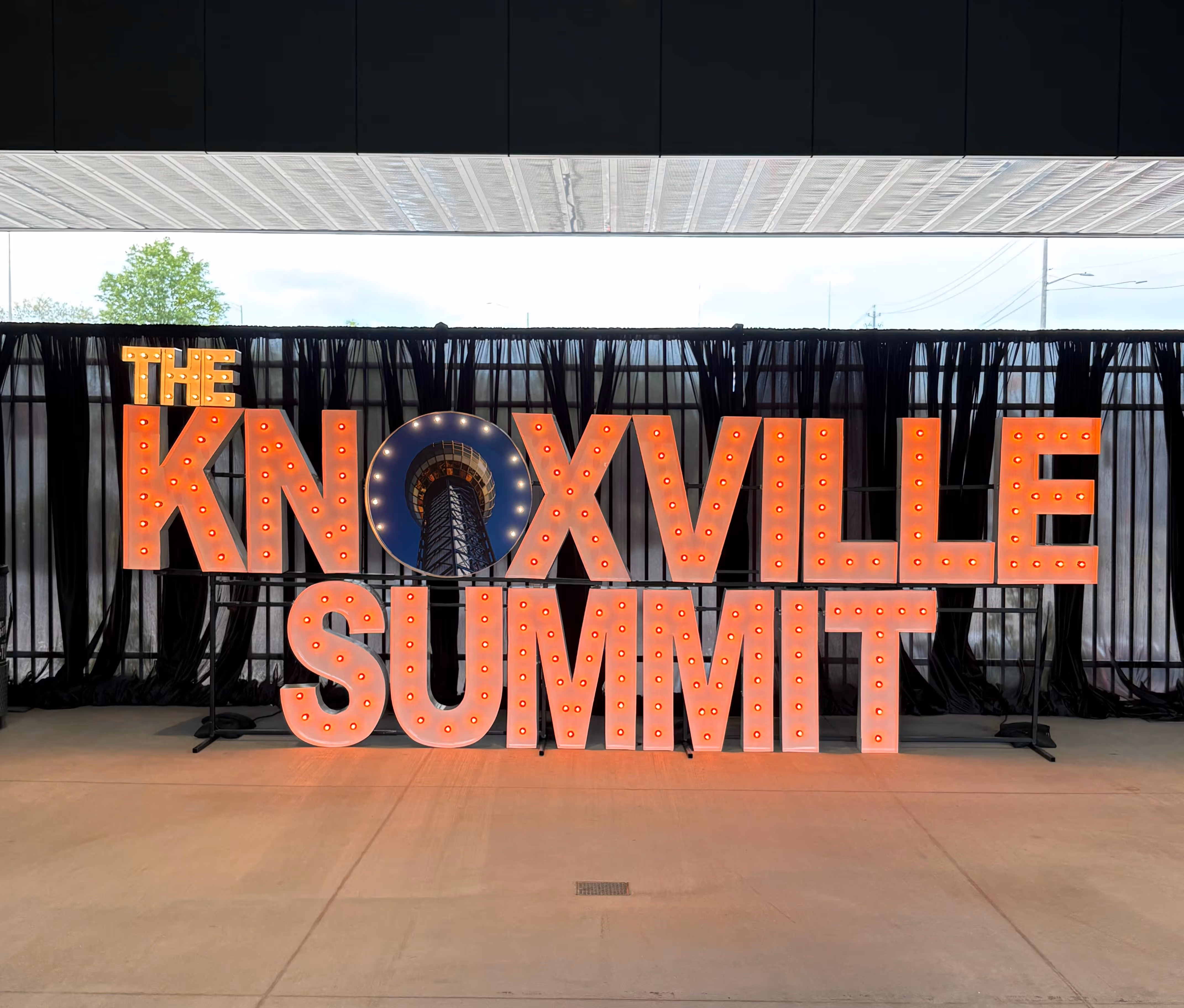 Lit letters spelling HVMS in front of silver and blue balloons at Hardin Valley Middle School with mural stars and music notes on the wall.
