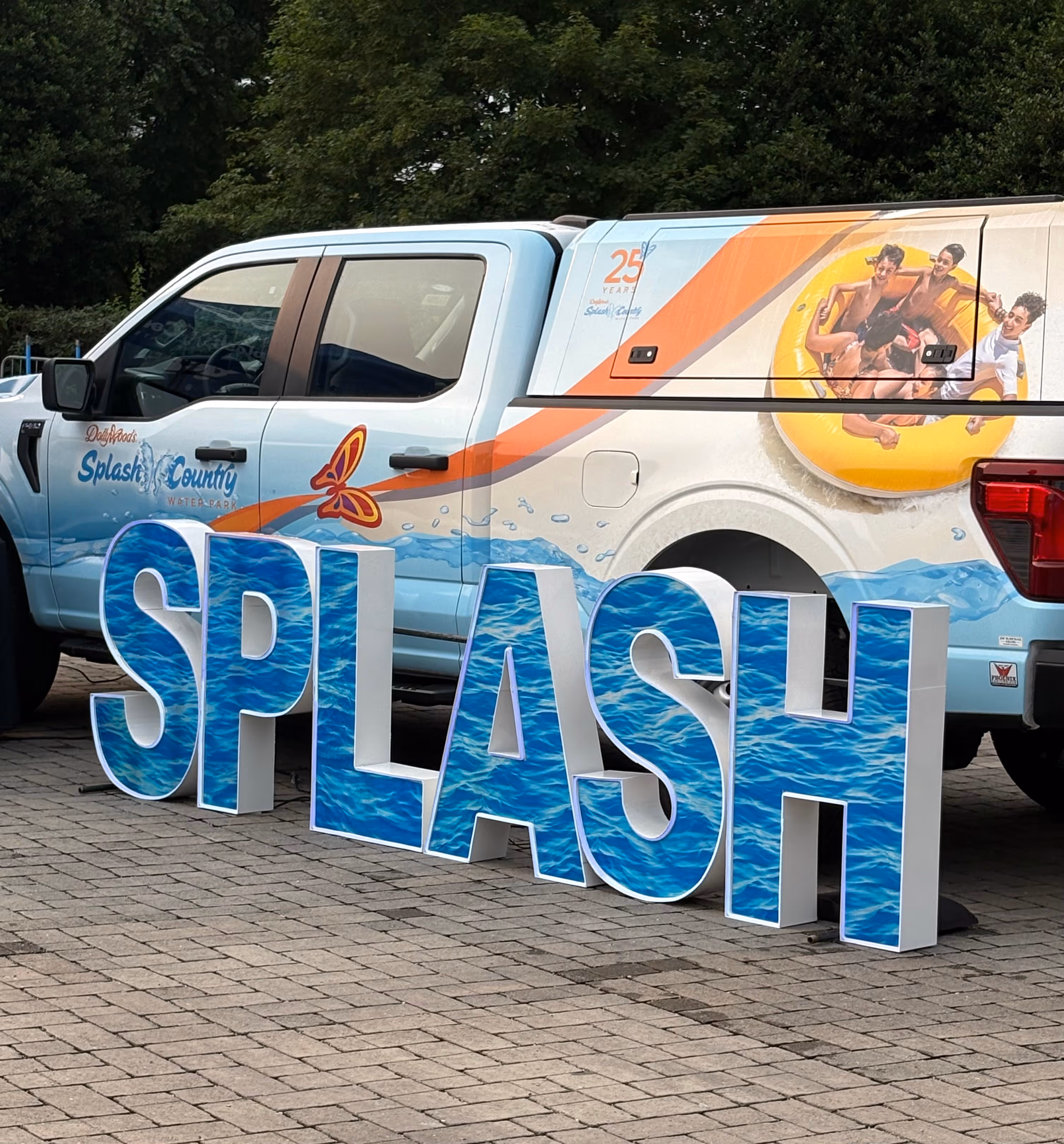 Lit letters spelling HVMS in front of silver and blue balloons at Hardin Valley Middle School with mural stars and music notes on the wall.