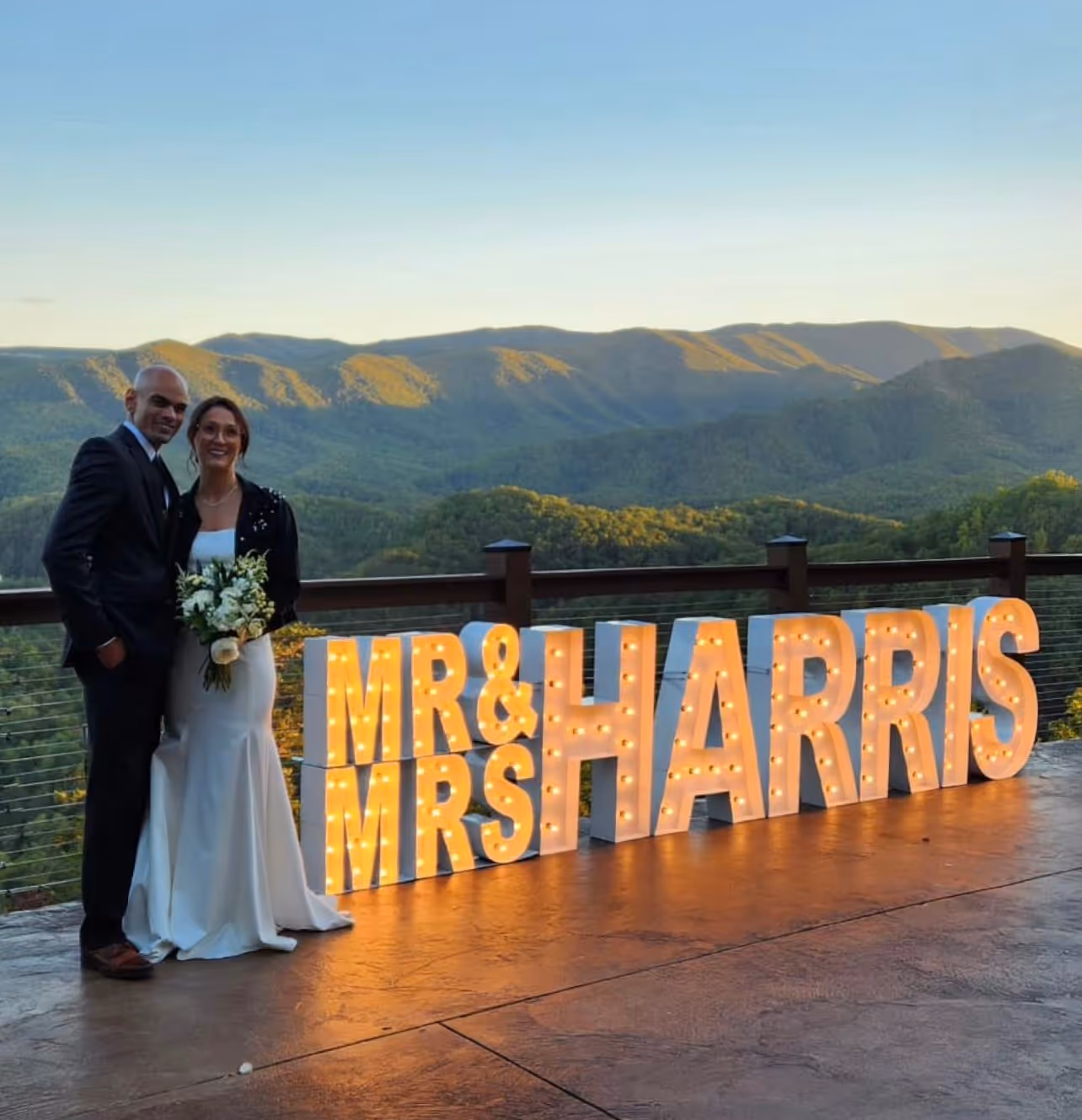 Lit letters spelling HVMS in front of silver and blue balloons at Hardin Valley Middle School with mural stars and music notes on the wall.
