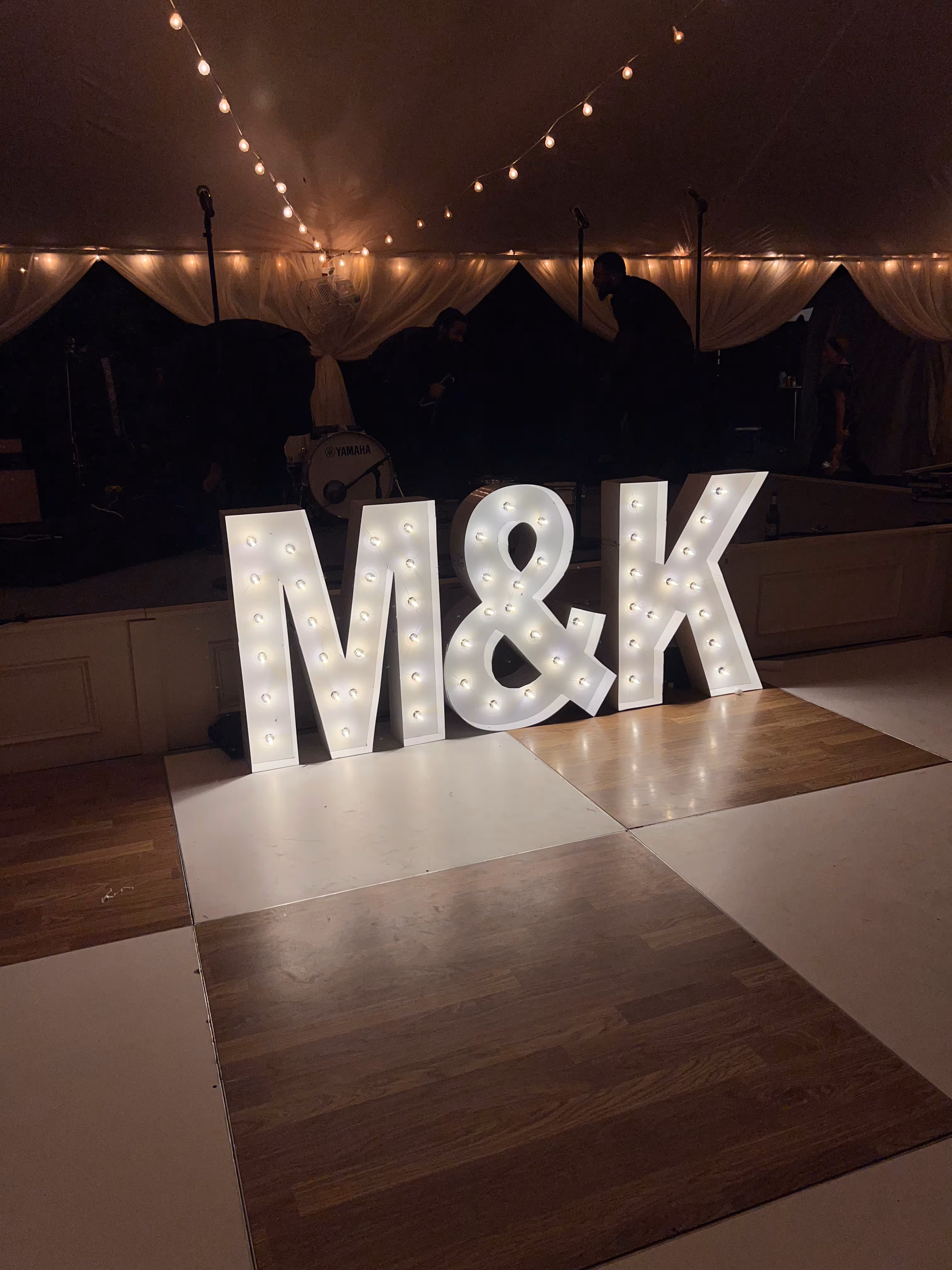 Lit letters spelling HVMS in front of silver and blue balloons at Hardin Valley Middle School with mural stars and music notes on the wall.