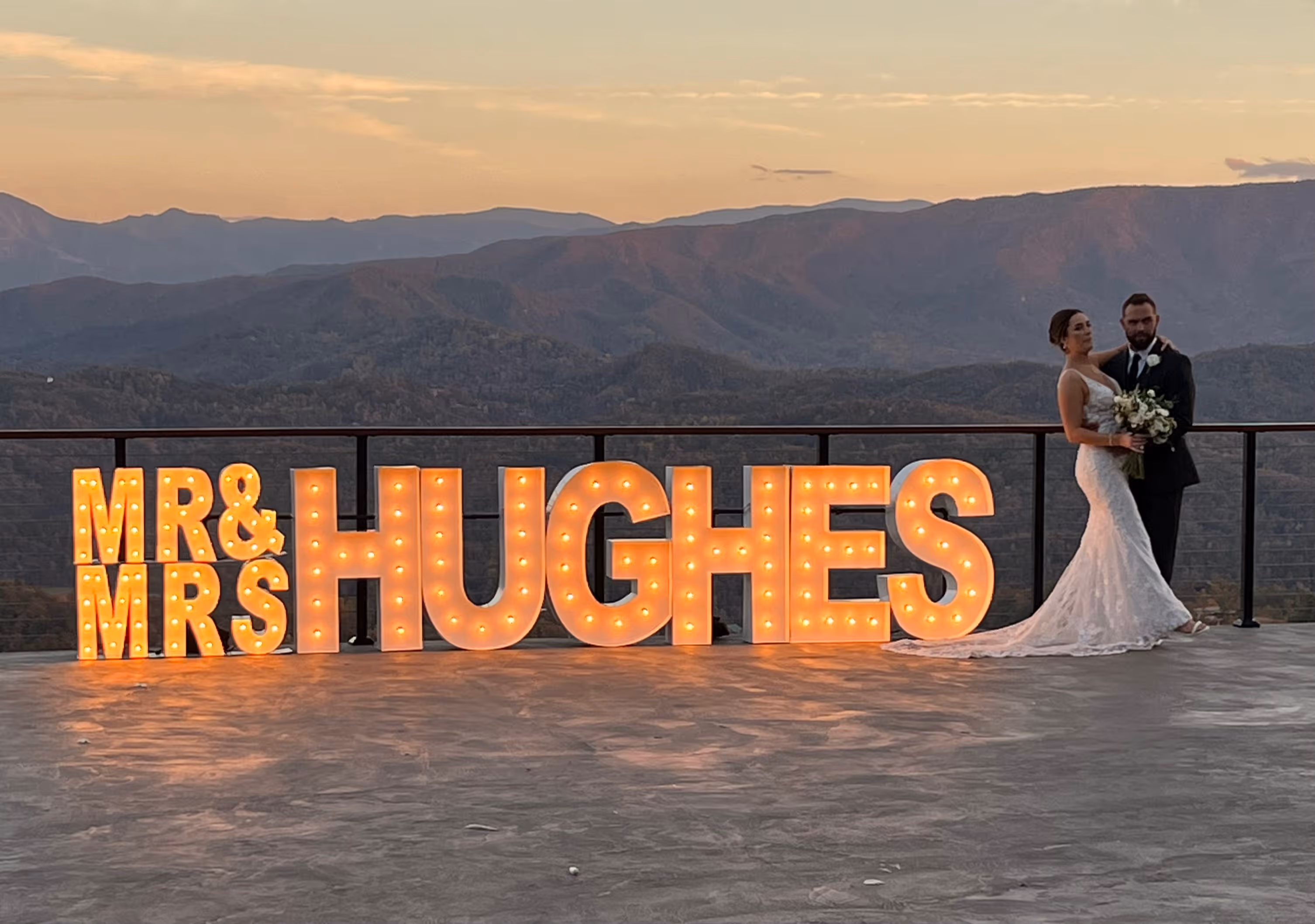 Lit letters spelling HVMS in front of silver and blue balloons at Hardin Valley Middle School with mural stars and music notes on the wall.