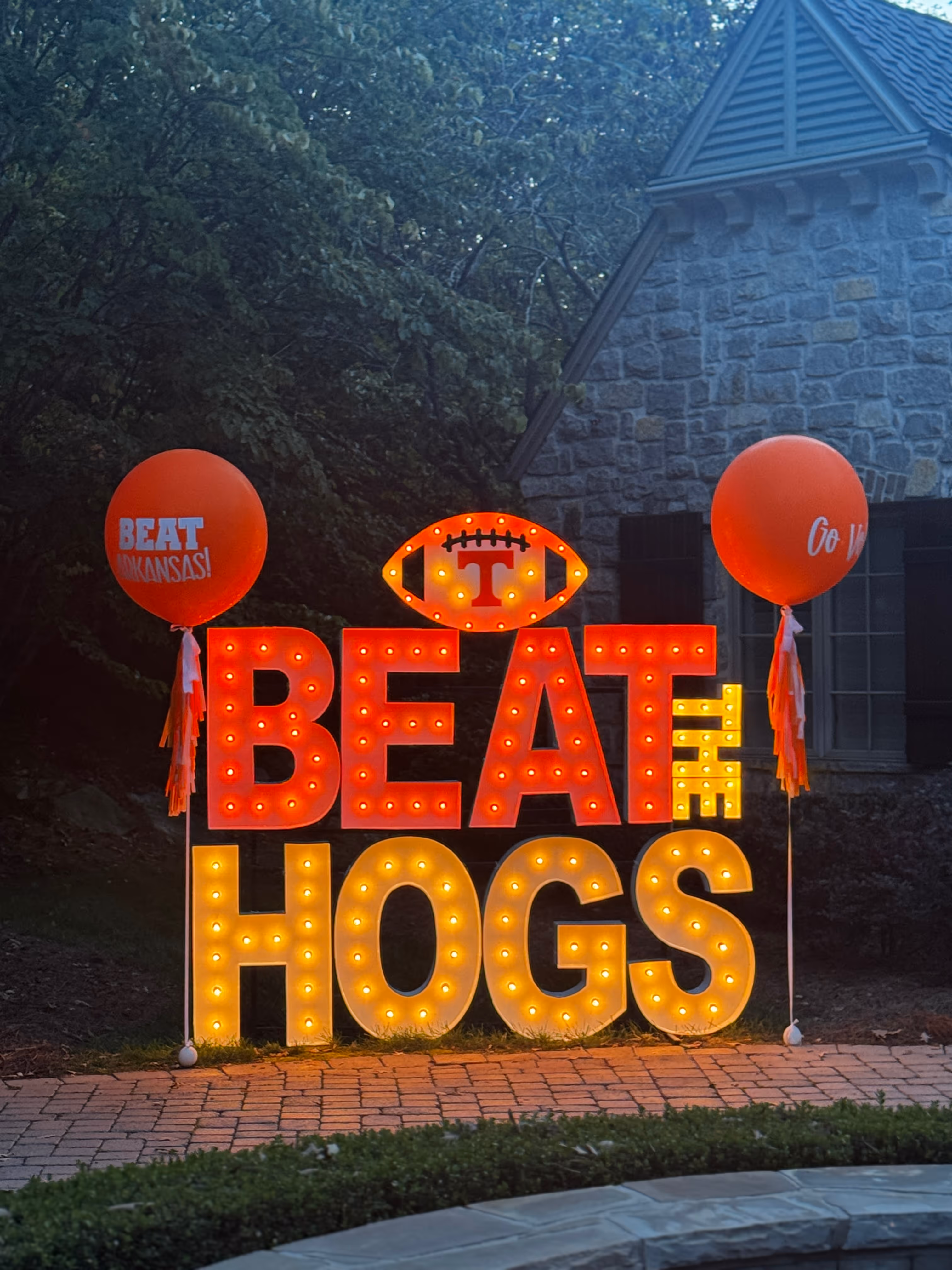 Lit letters spelling HVMS in front of silver and blue balloons at Hardin Valley Middle School with mural stars and music notes on the wall.