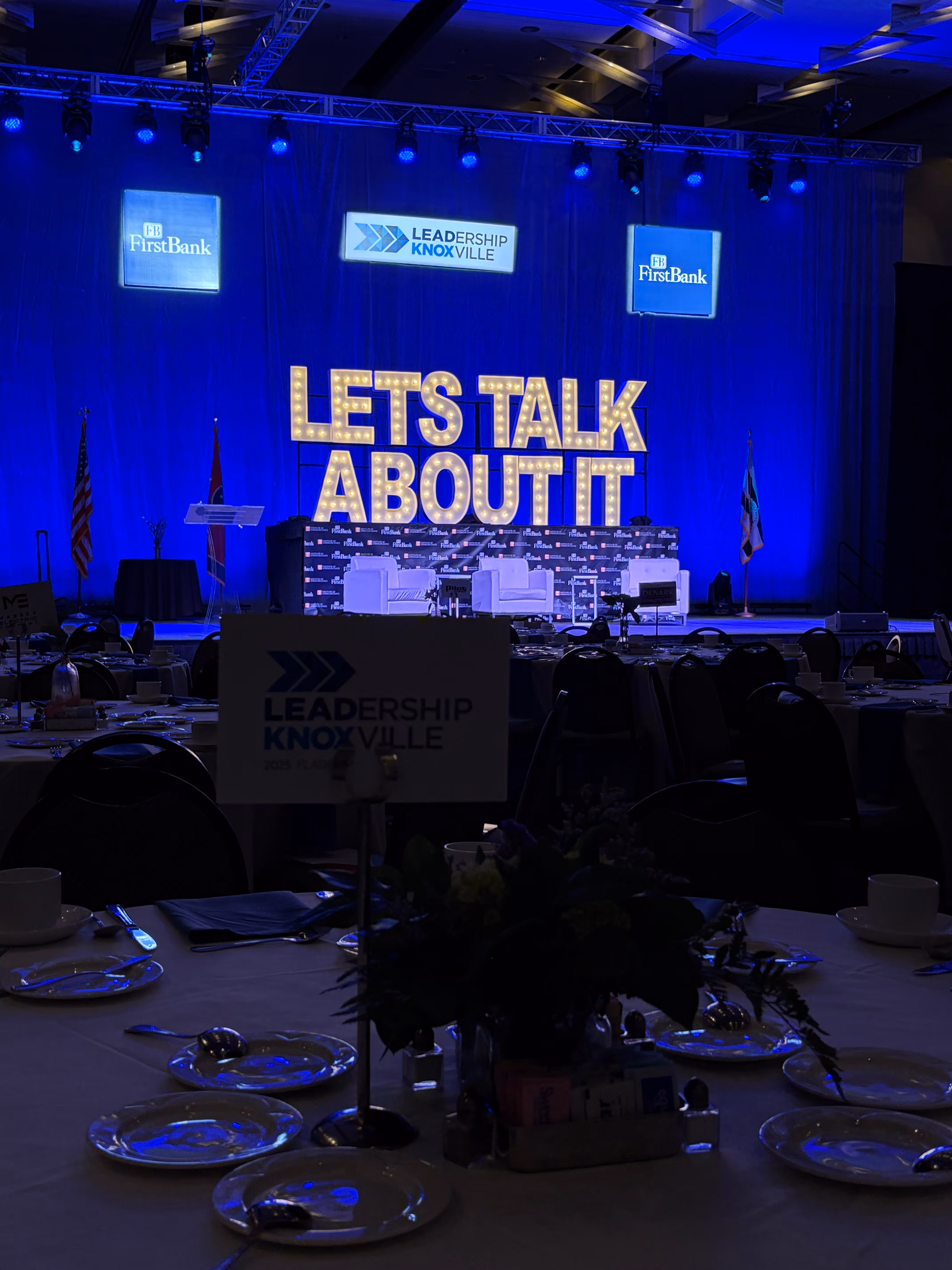 Lit letters spelling HVMS in front of silver and blue balloons at Hardin Valley Middle School with mural stars and music notes on the wall.