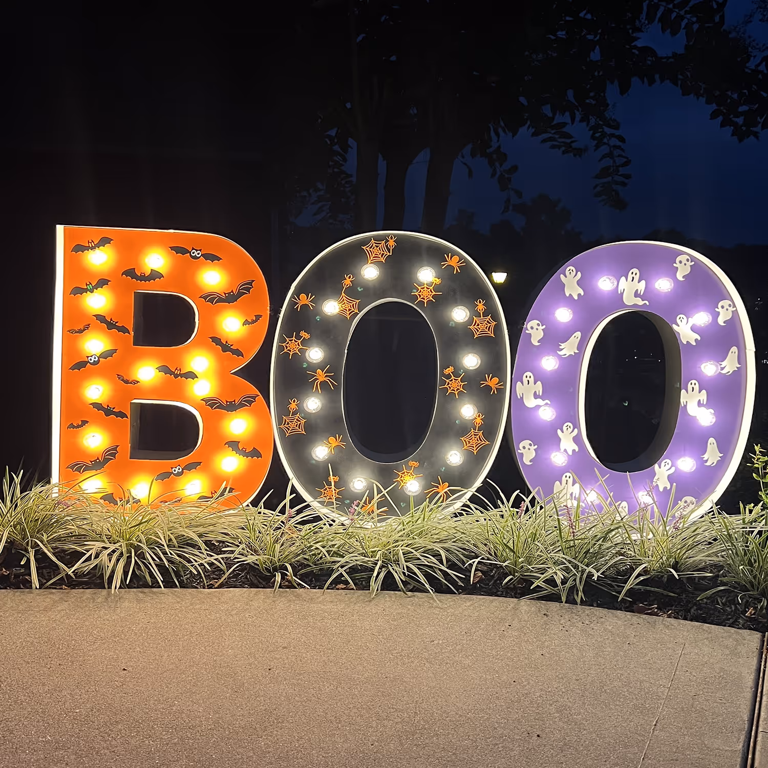 Lit letters spelling HVMS in front of silver and blue balloons at Hardin Valley Middle School with mural stars and music notes on the wall.