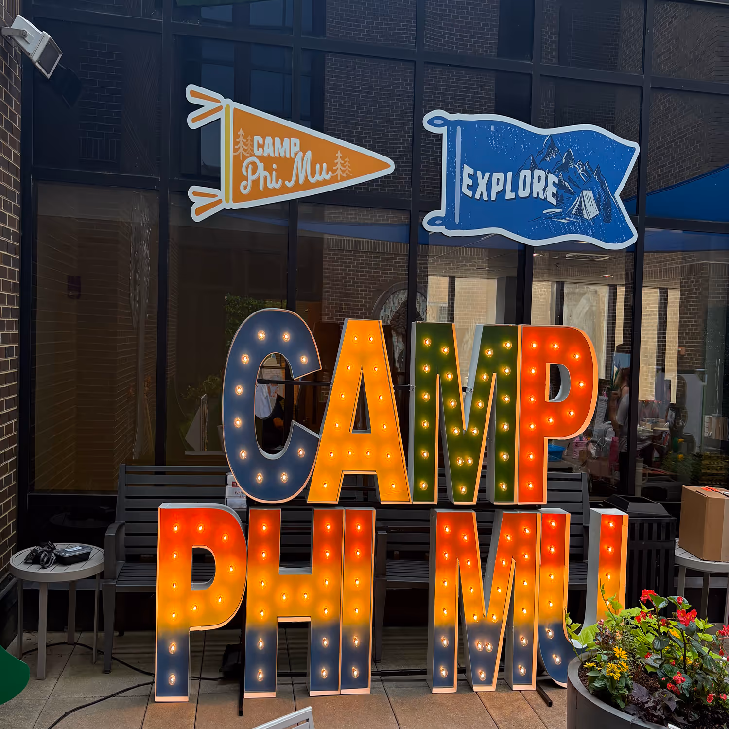 Lit letters spelling HVMS in front of silver and blue balloons at Hardin Valley Middle School with mural stars and music notes on the wall.