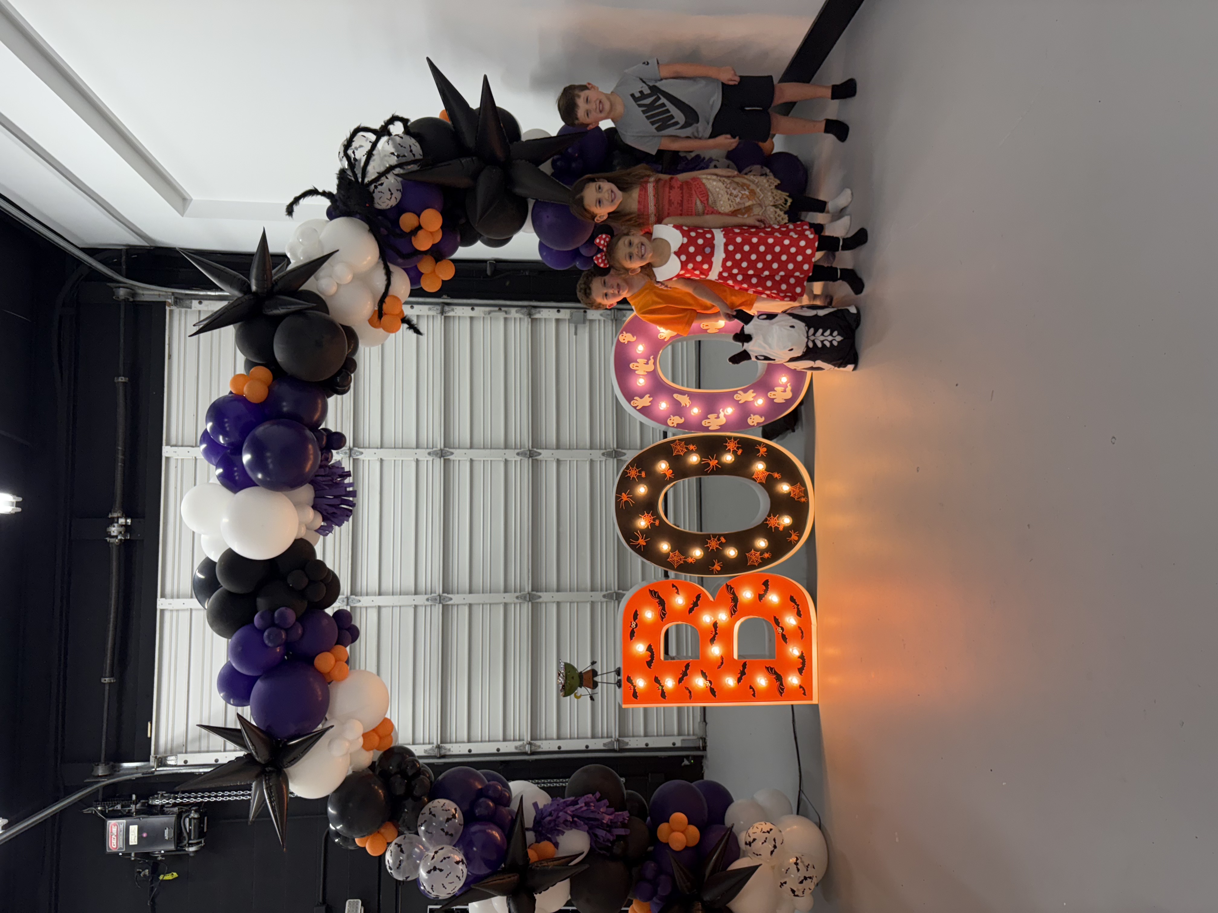 Lit letters spelling HVMS in front of silver and blue balloons at Hardin Valley Middle School with mural stars and music notes on the wall.