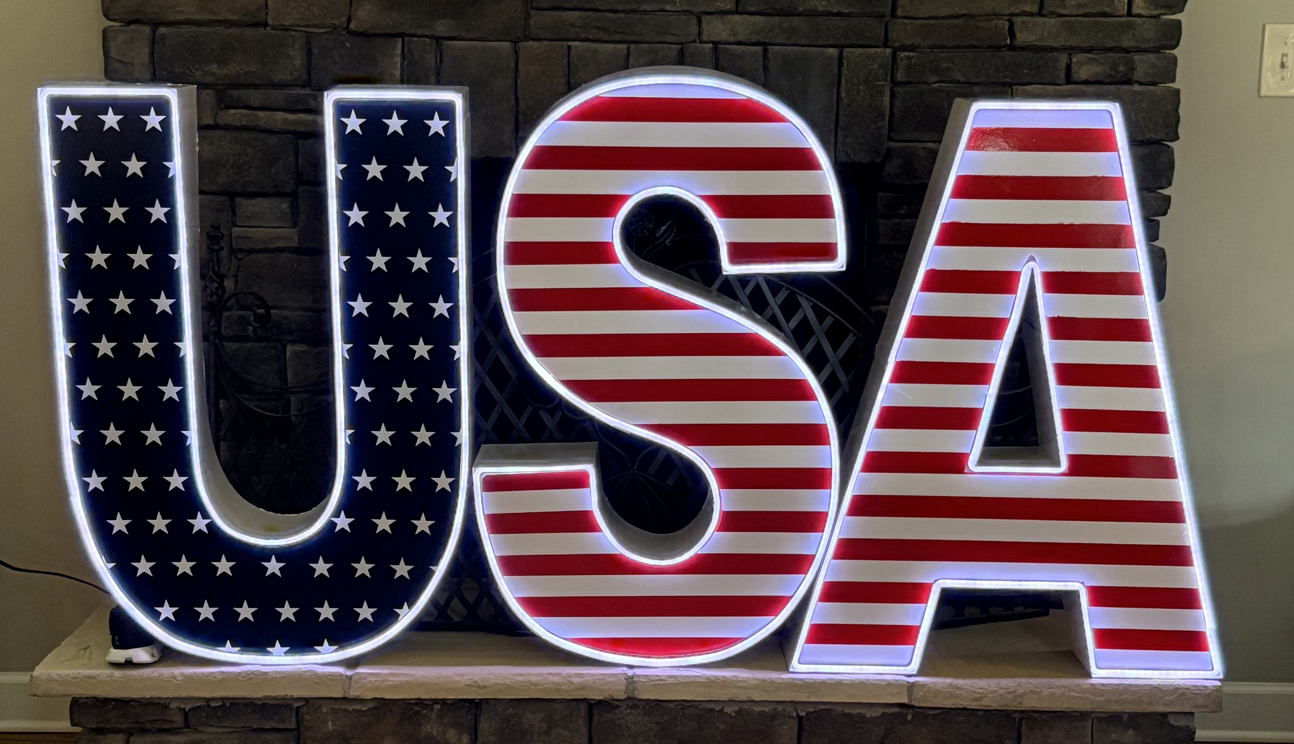 Lit letters spelling HVMS in front of silver and blue balloons at Hardin Valley Middle School with mural stars and music notes on the wall.
