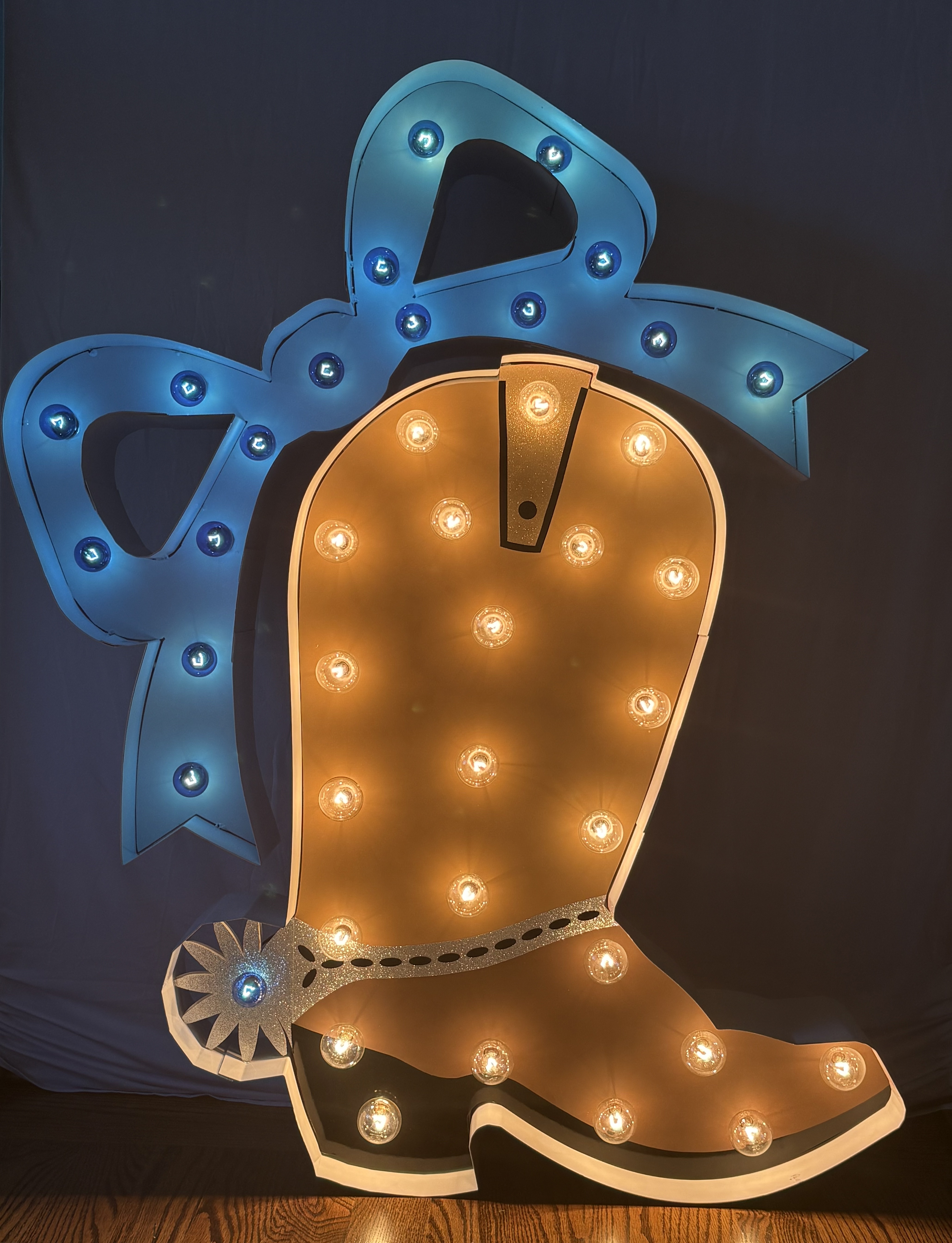 Lit letters spelling HVMS in front of silver and blue balloons at Hardin Valley Middle School with mural stars and music notes on the wall.