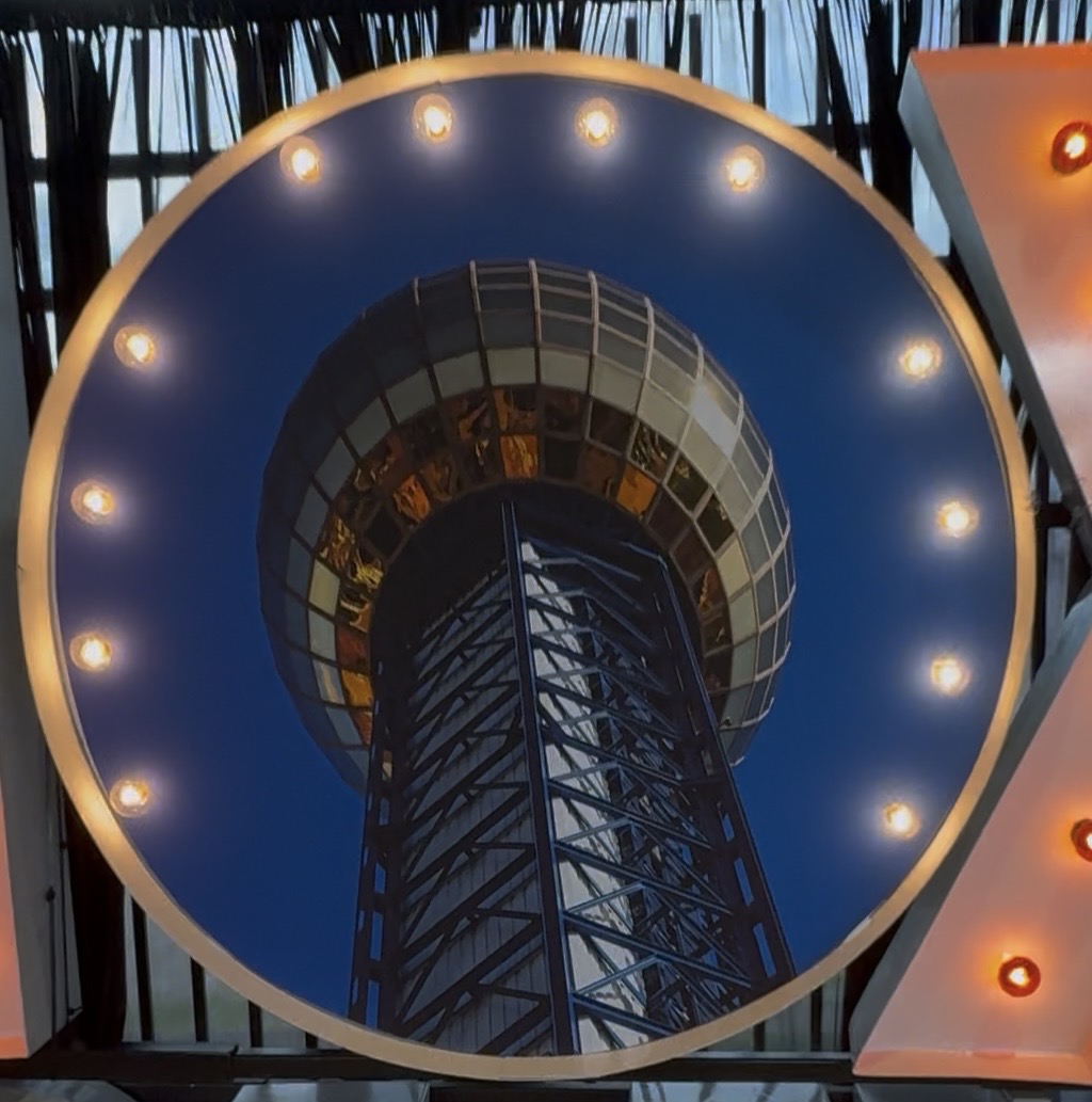 Lit letters spelling HVMS in front of silver and blue balloons at Hardin Valley Middle School with mural stars and music notes on the wall.