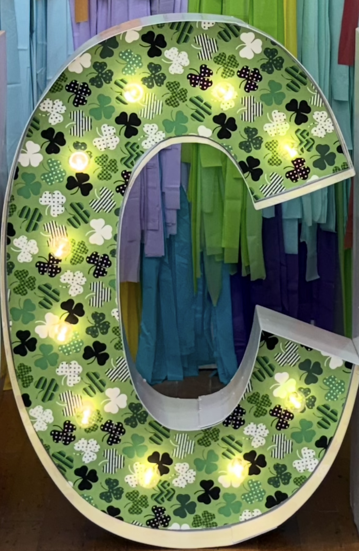 Lit letters spelling HVMS in front of silver and blue balloons at Hardin Valley Middle School with mural stars and music notes on the wall.