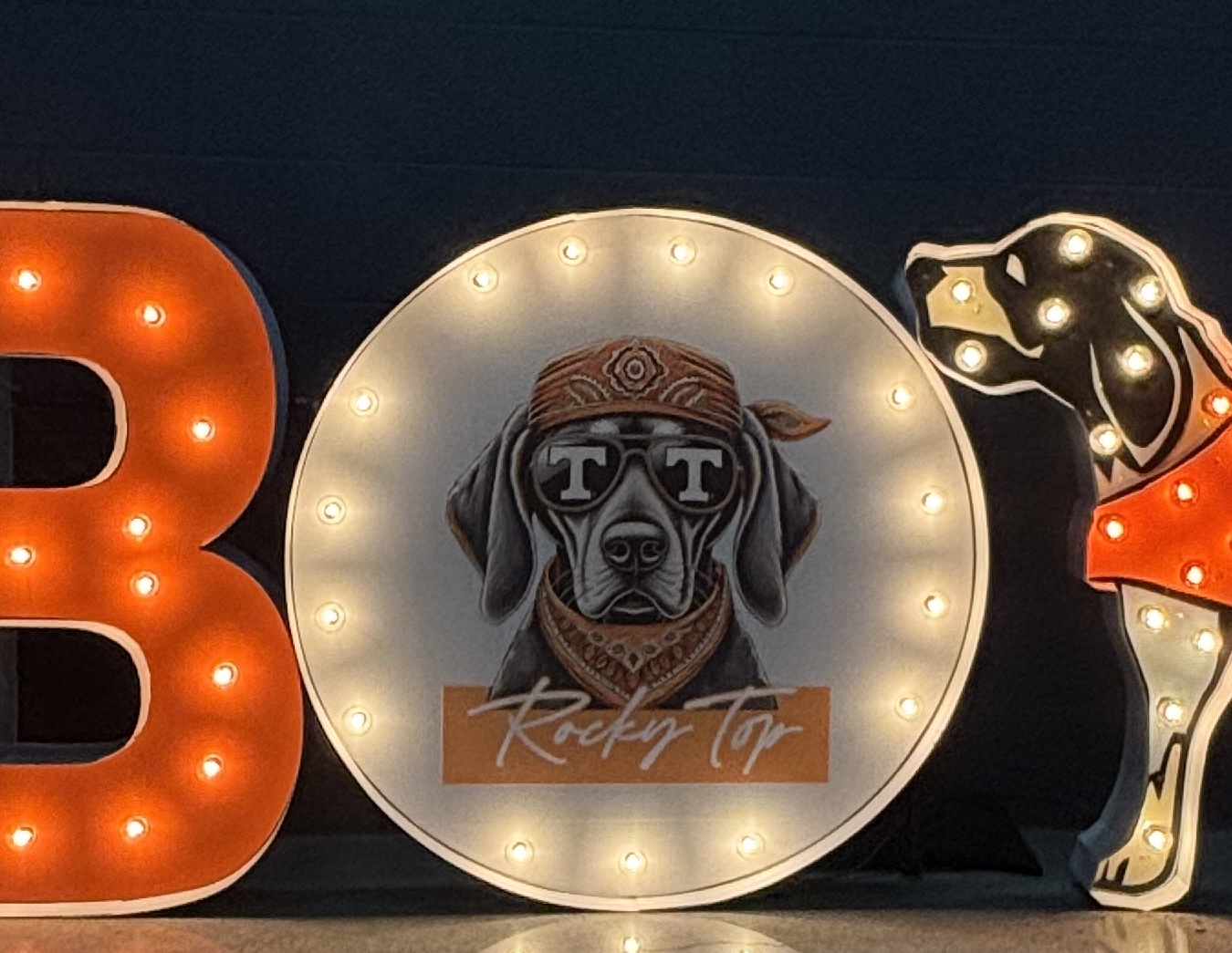 Lit letters spelling HVMS in front of silver and blue balloons at Hardin Valley Middle School with mural stars and music notes on the wall.