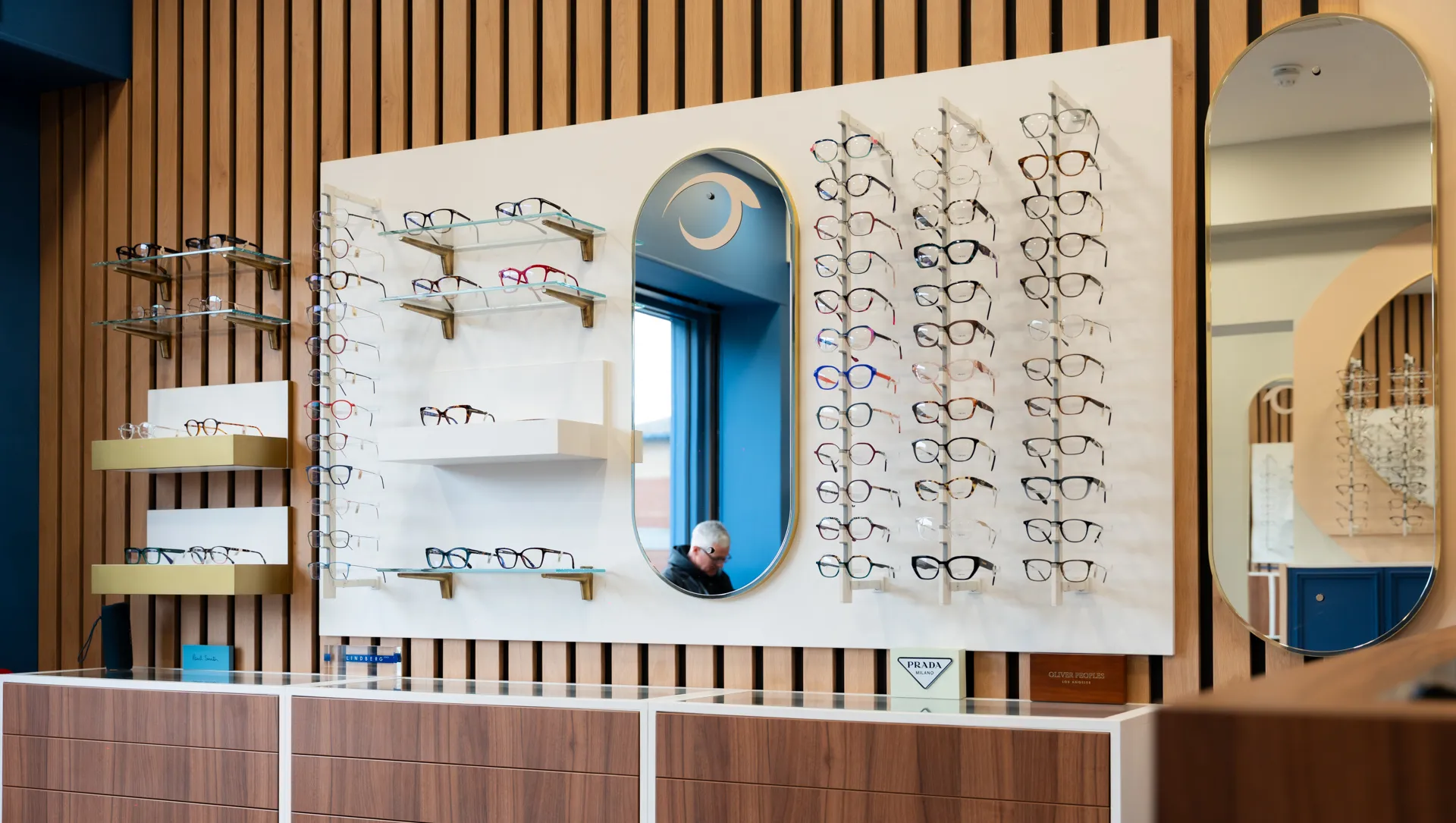Eyeglass display with multiple frames on shelves in modern optical store