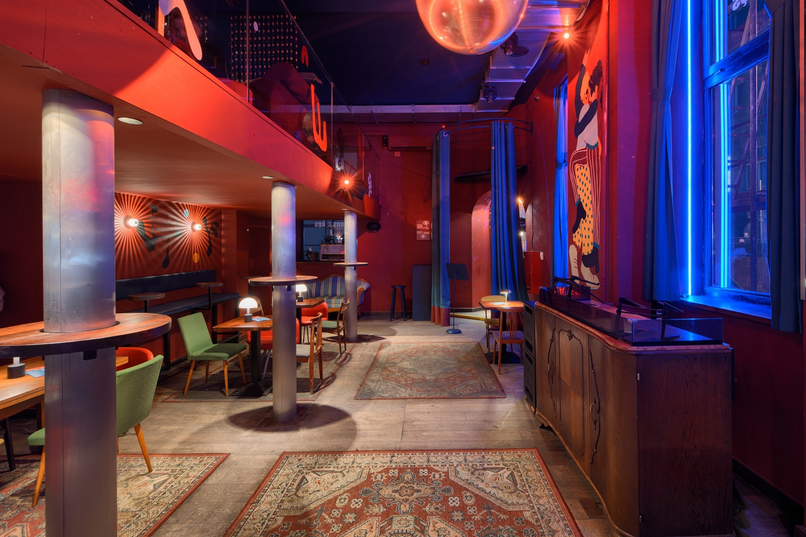 Bar interior with a teal counter, shelves stocked with liquor bottles, a disco ball hanging from the ceiling, and a red neon sign reading 'BEEFEATER'.