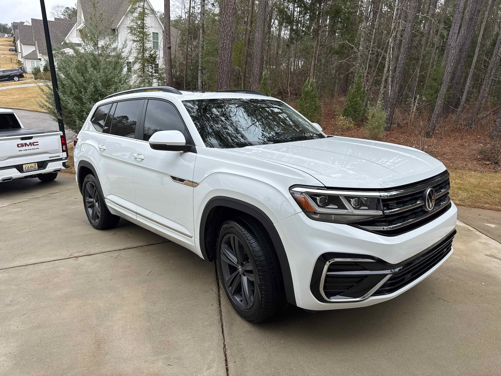 White Volkswagen SUV parked on a driveway with black rims and tinted windows.