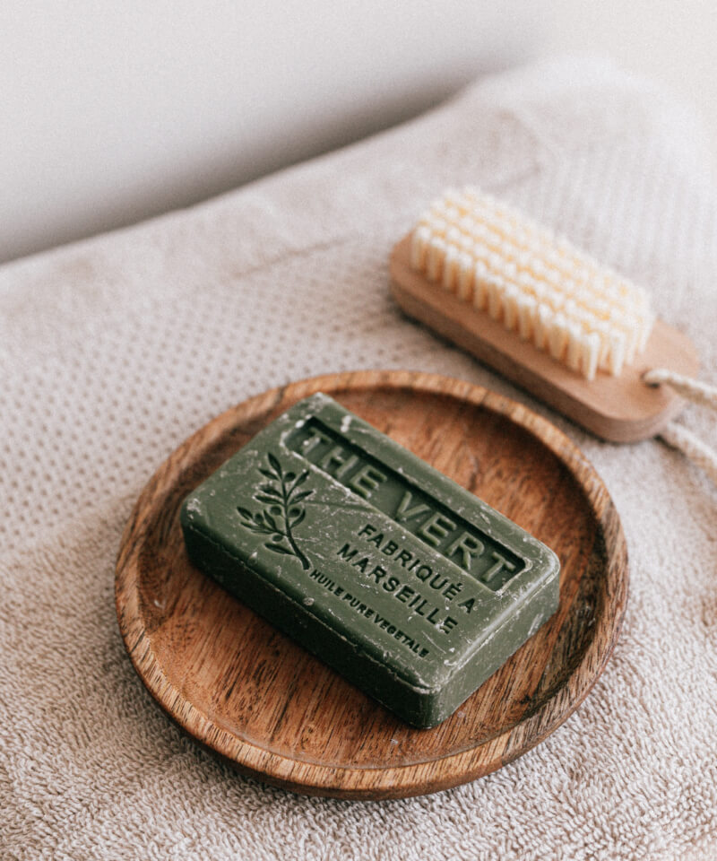 Olive colored soap in wooden soap dish