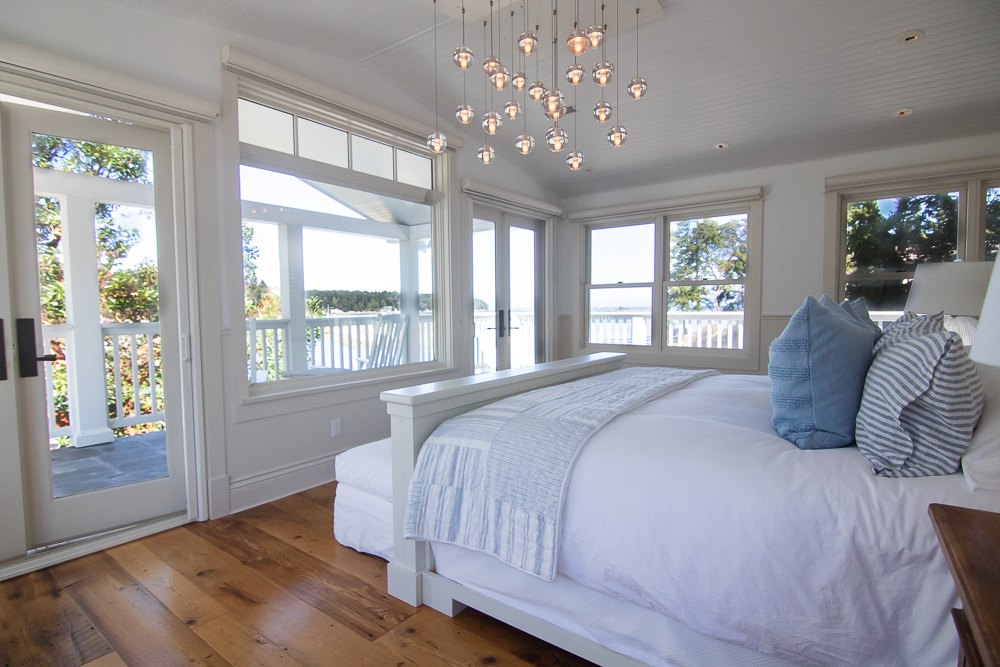 Primary suite with French doors opening onto the upper veranda and views of the water