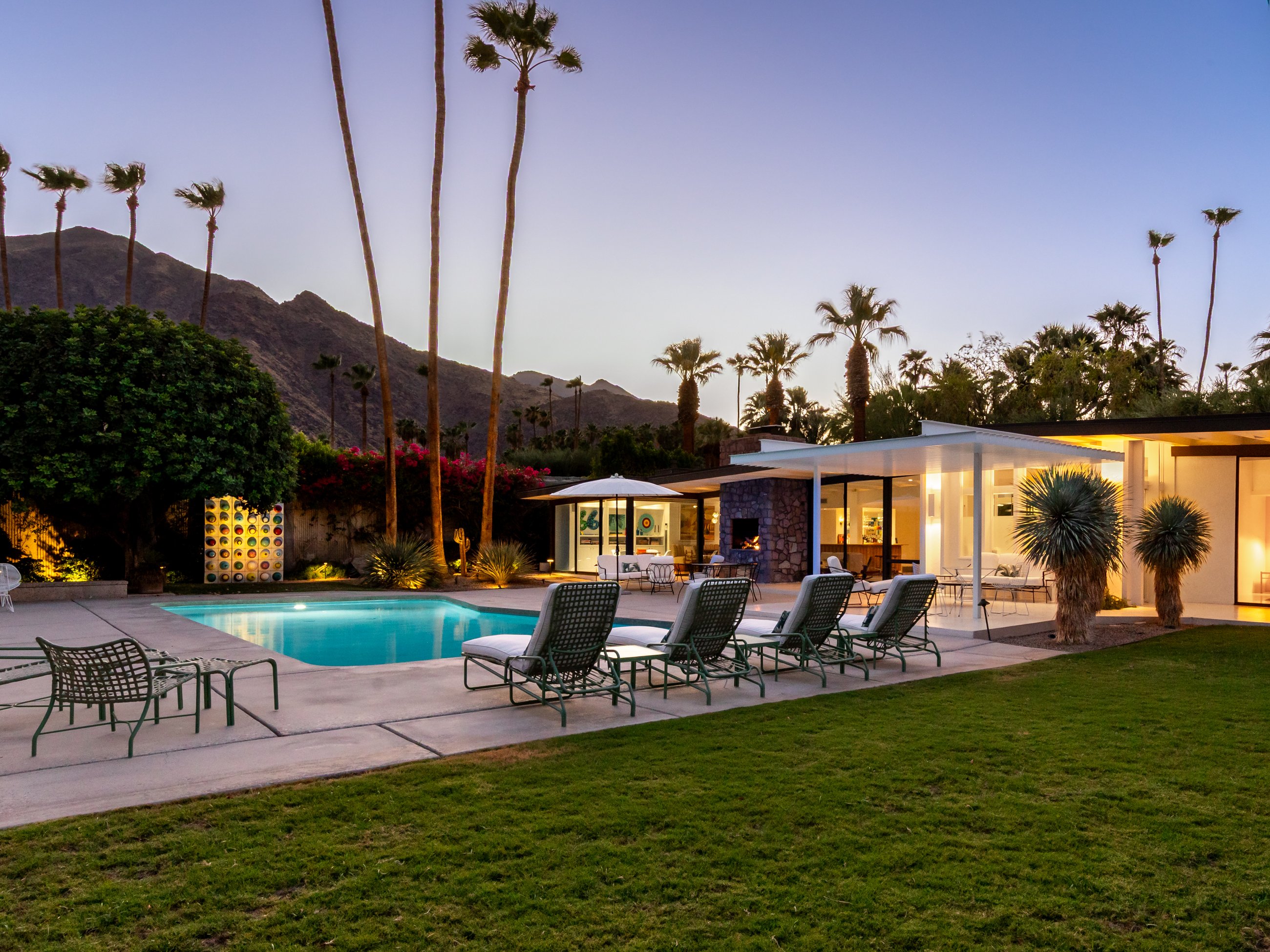 Lawn, pool and residence at dusk with the San Jacinto Mountains