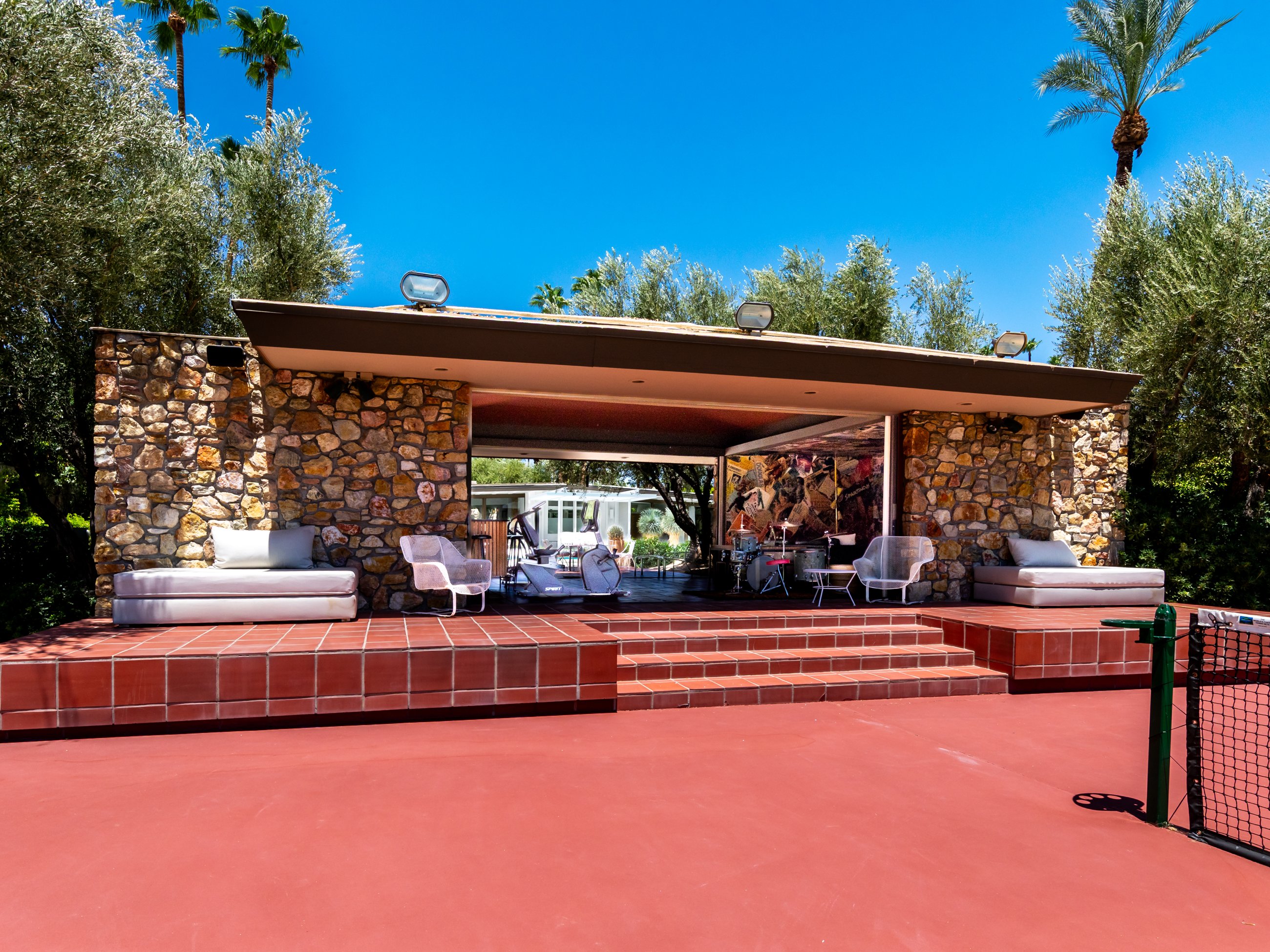 Stone tennis pavilion with lounge and fitness area