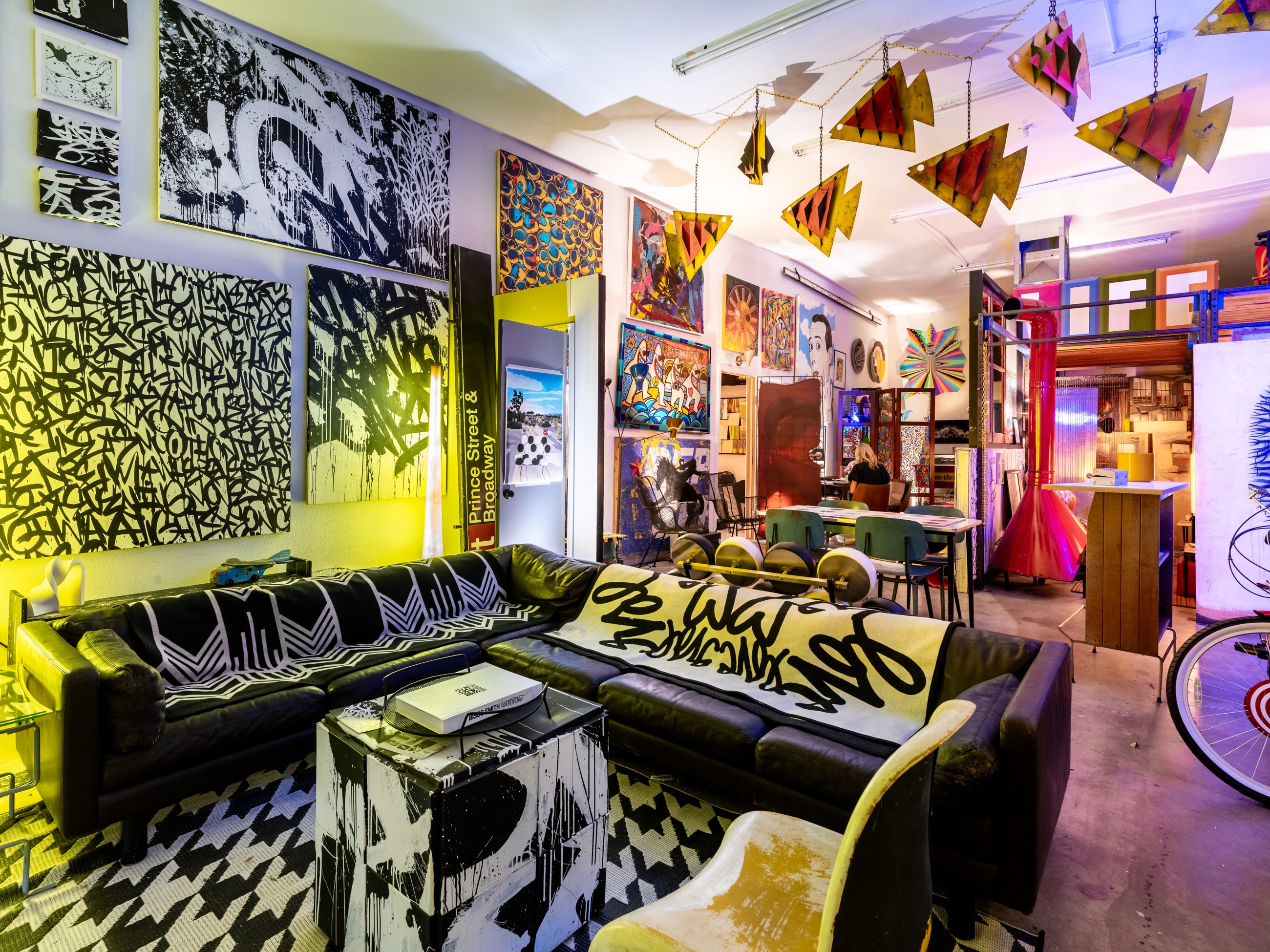 Leather sectional beneath large black and white calligraphy paintings