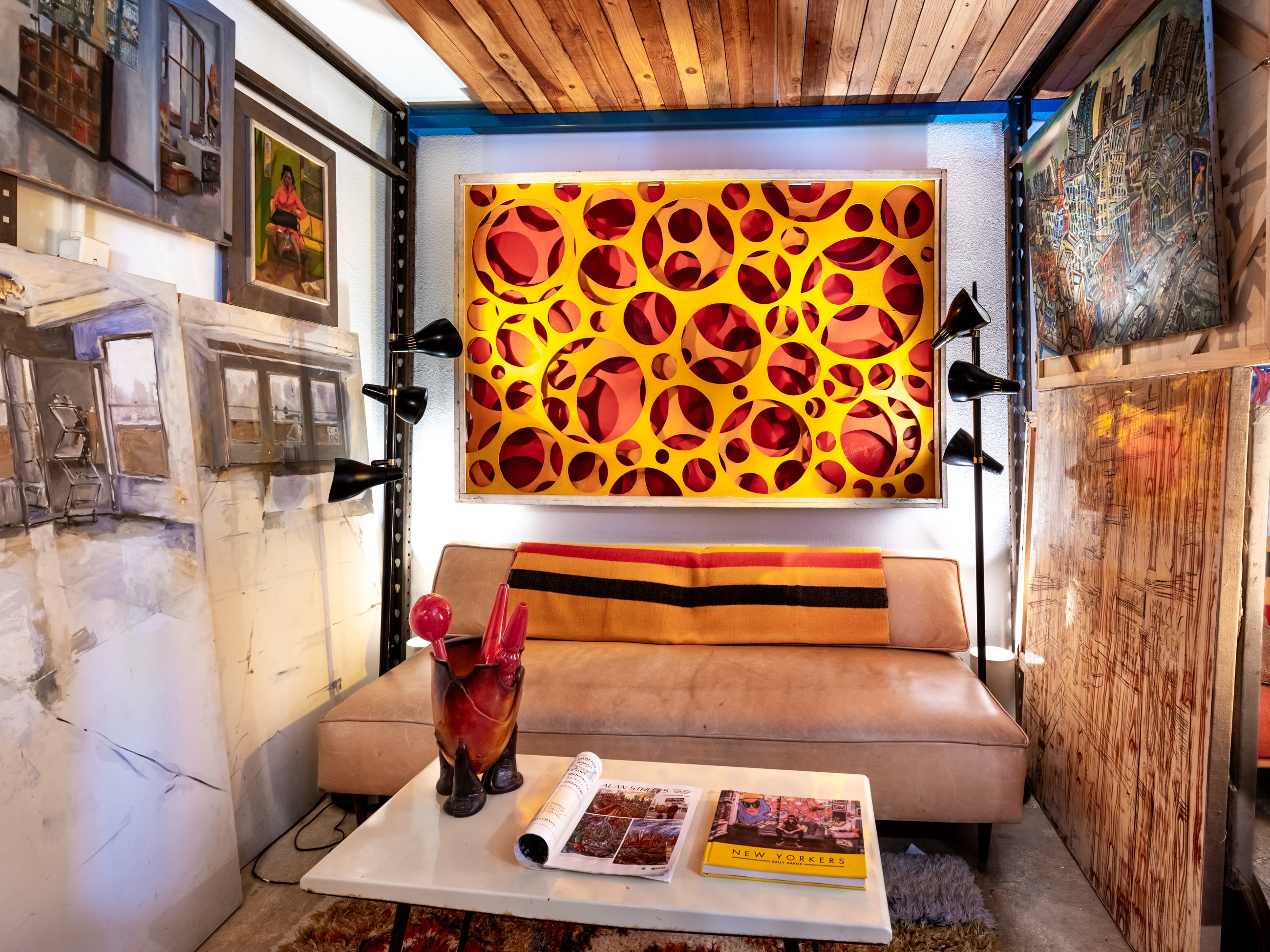 Sitting nook with a glowing cut circle artwork and vintage lamps