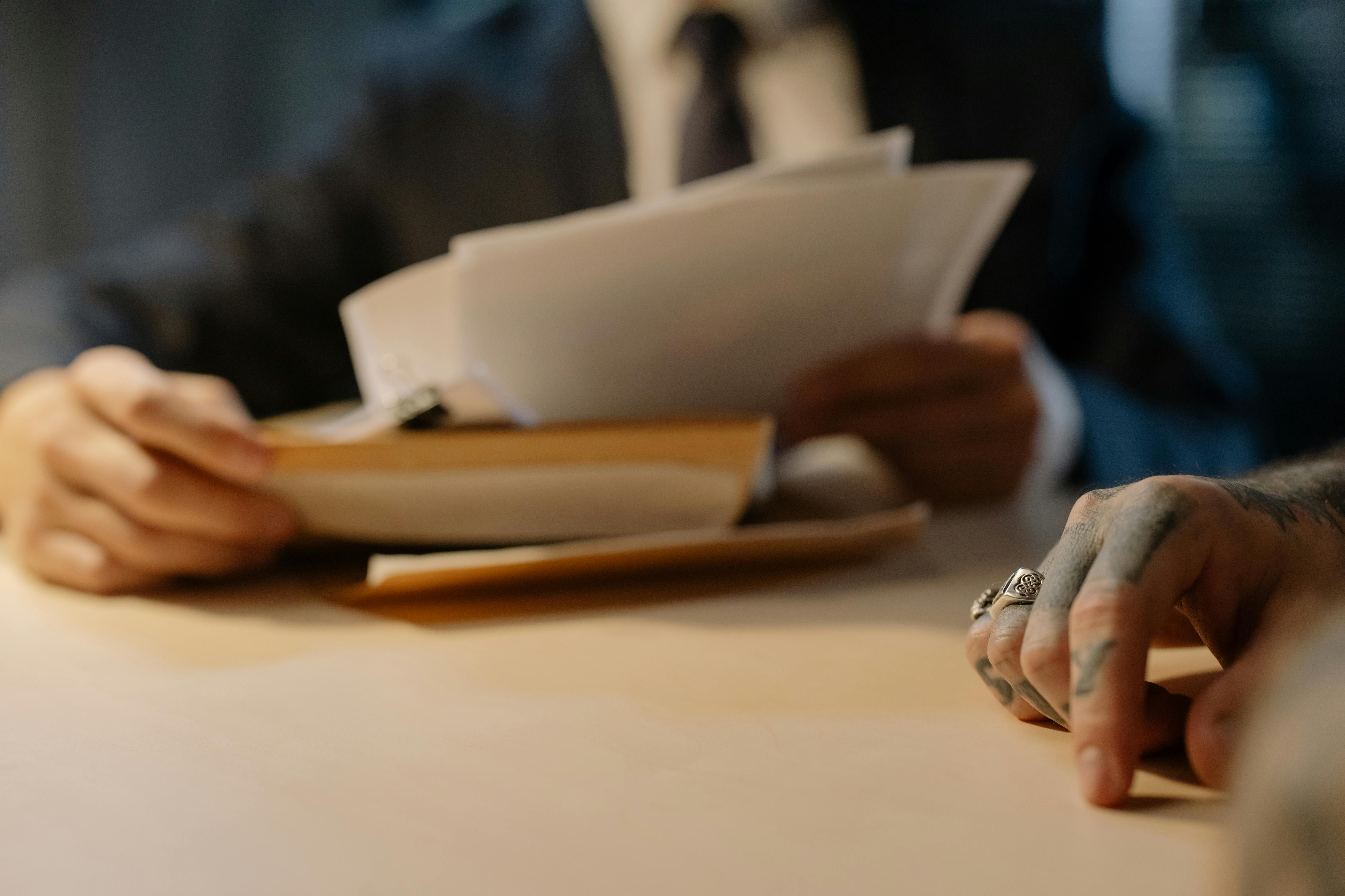Legal counsel reviewing case files during a client meeting.