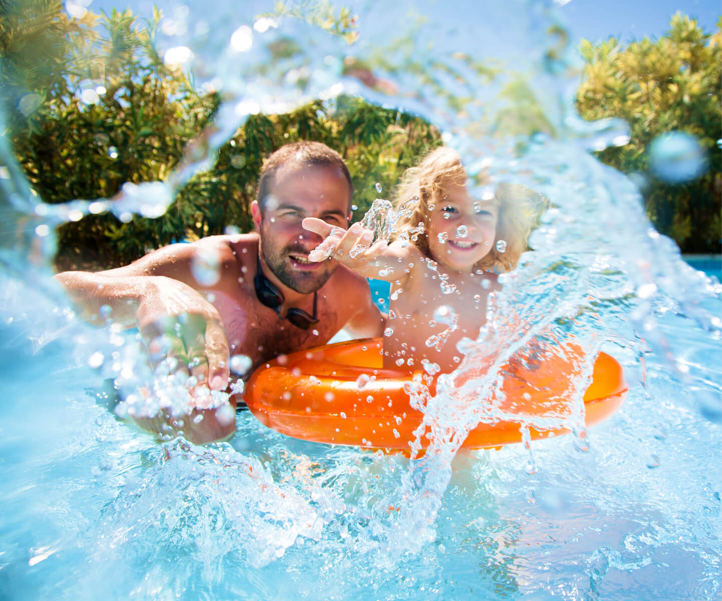 A father and his child splashing around the swimming room