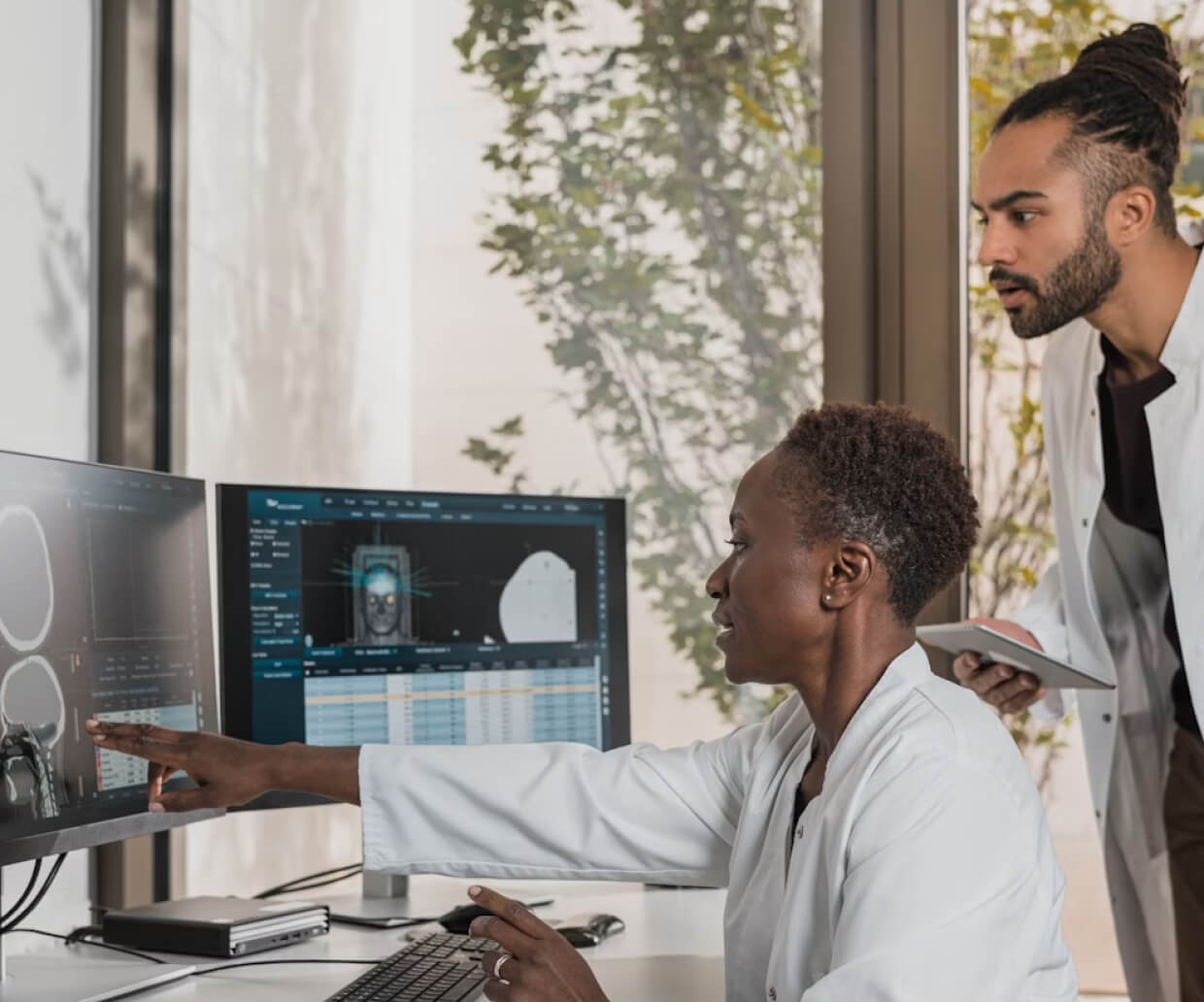 Two researchers discussing results using 2 monitors