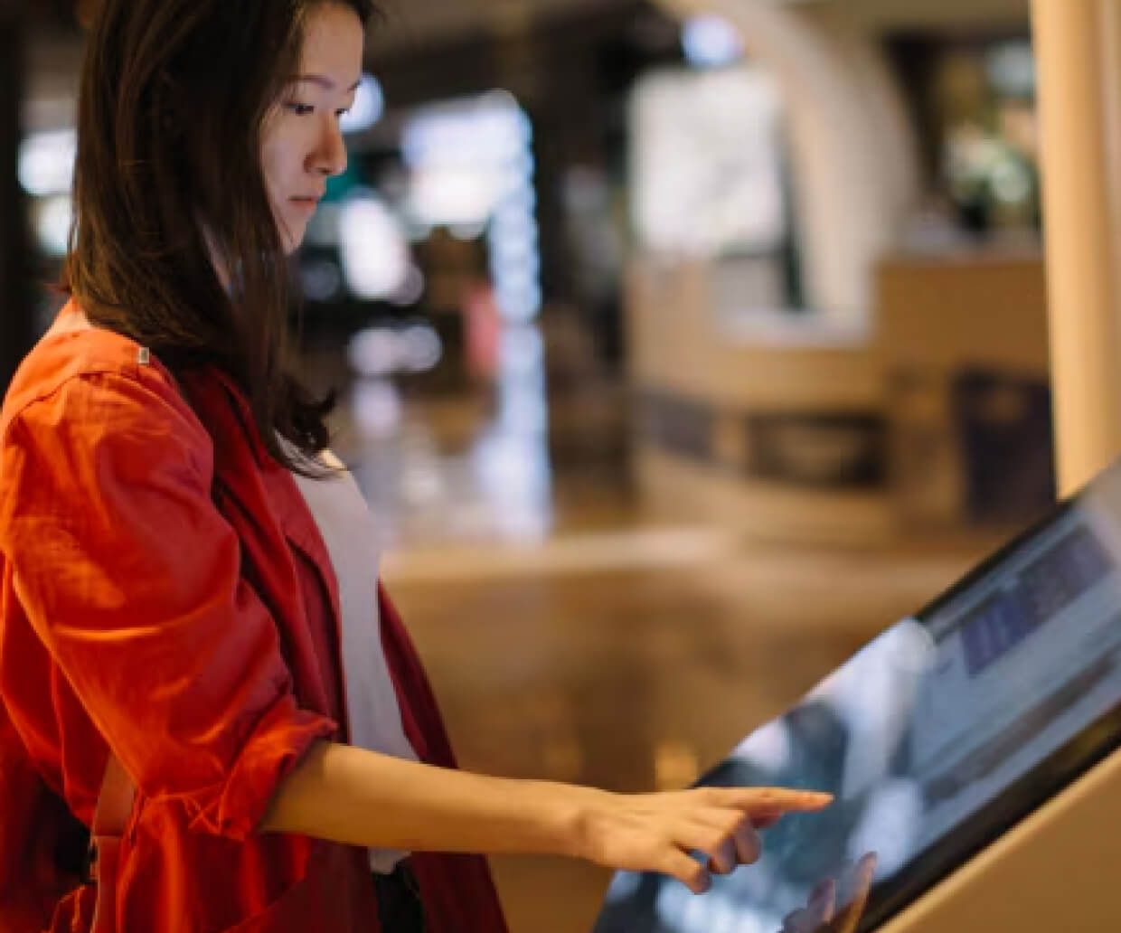 A woman using a touch kiosk