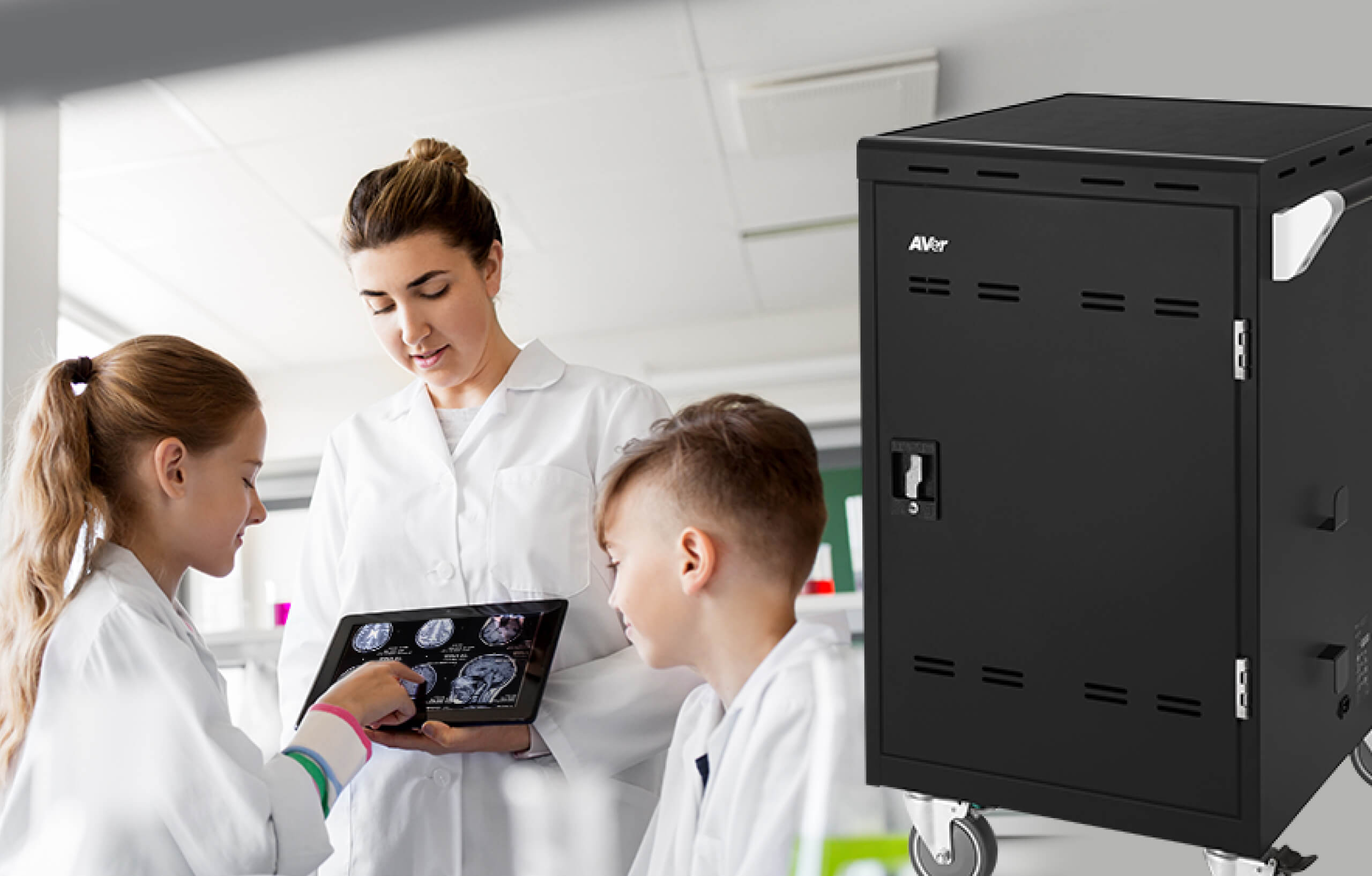 2 kids and a teacher looking at an iPad with images of brain scans