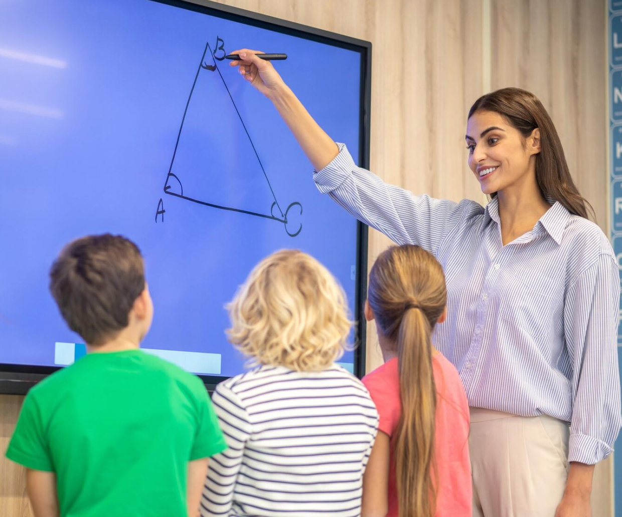 A teacher teaching geometry to 3 children