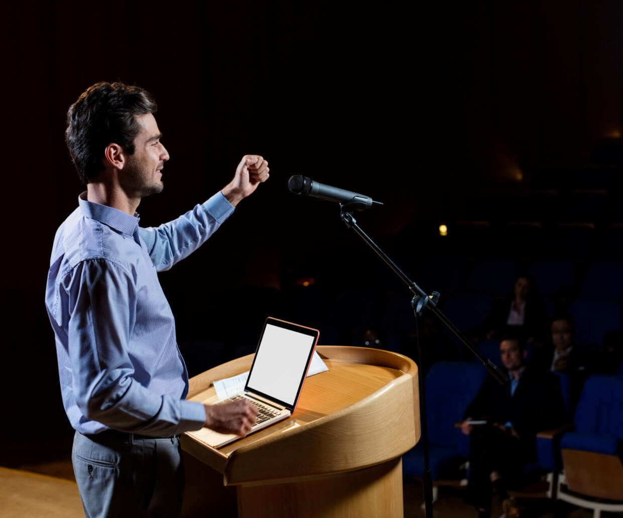 A man addressing his audience in the auditorium