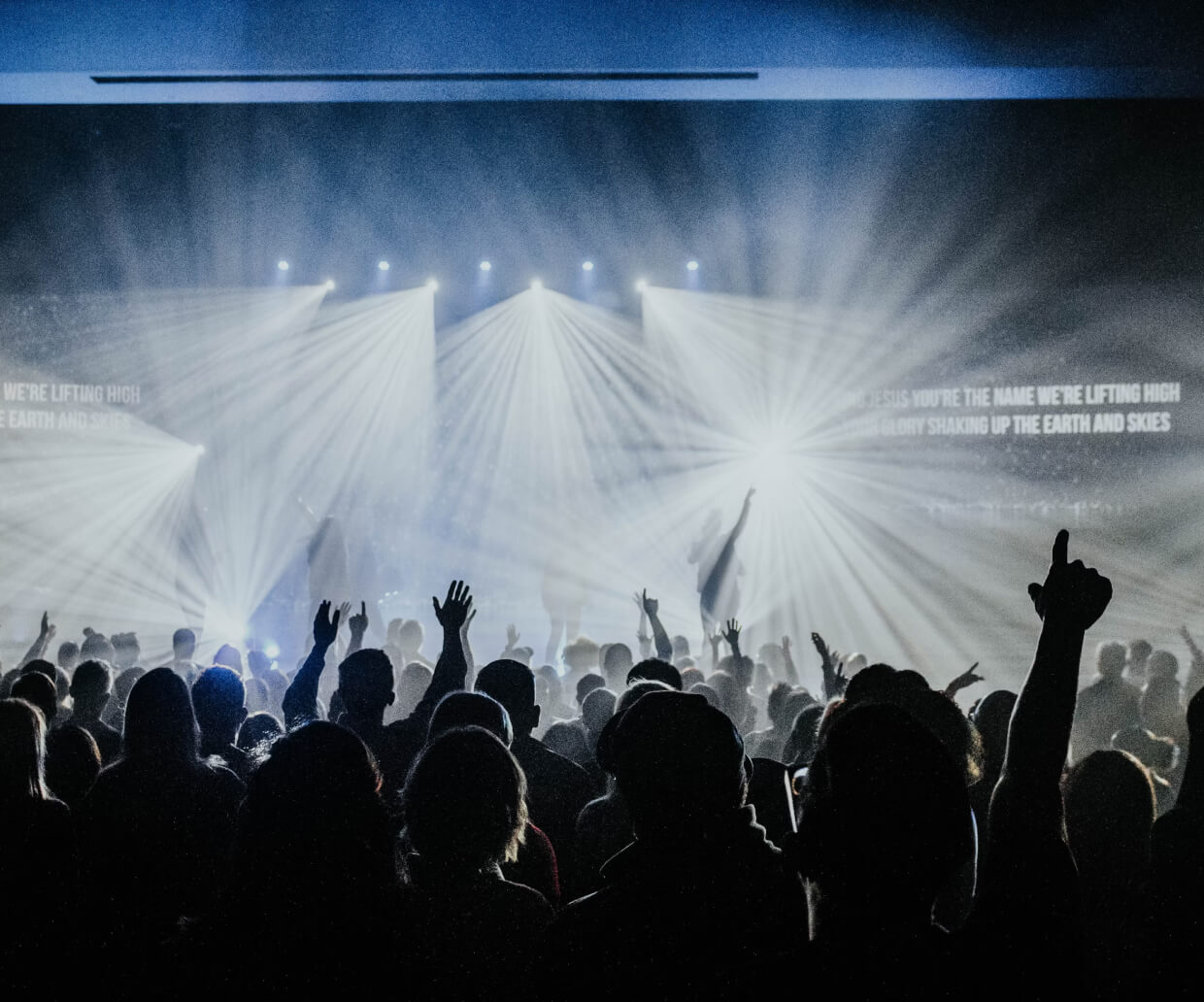 People cheering, raising their hands at an event