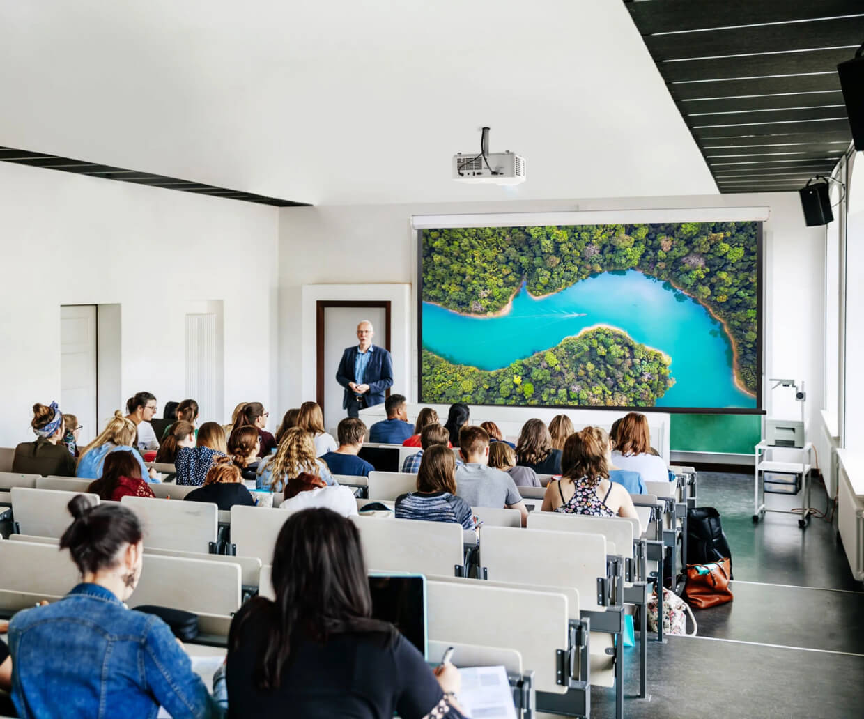 A teacher showing the class an image of a river, which is being projected onto the screen