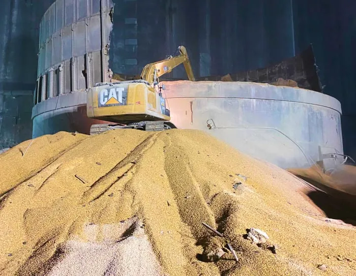 excavator on pile of grain