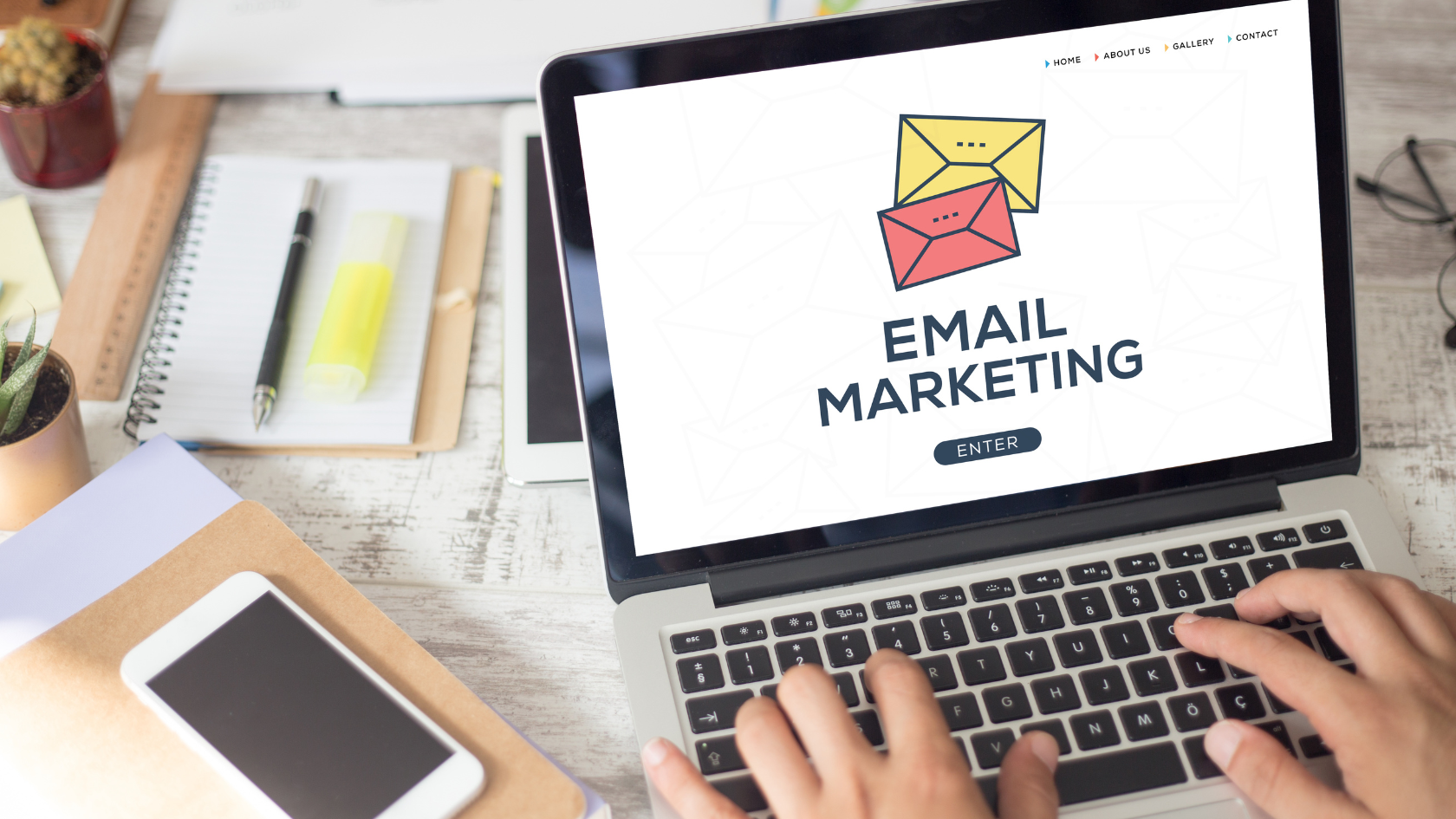 Laptop on a desk showing an EMAIL MARKETING landing page with envelope icons, hands typing on the keyboard and a notebook beside it, the cheap-acquisition-channel discipline behind the HVAC email marketing guide below.