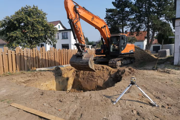 Graafmachine tijdens grondwerken voor fundering nieuwbouwwoning
