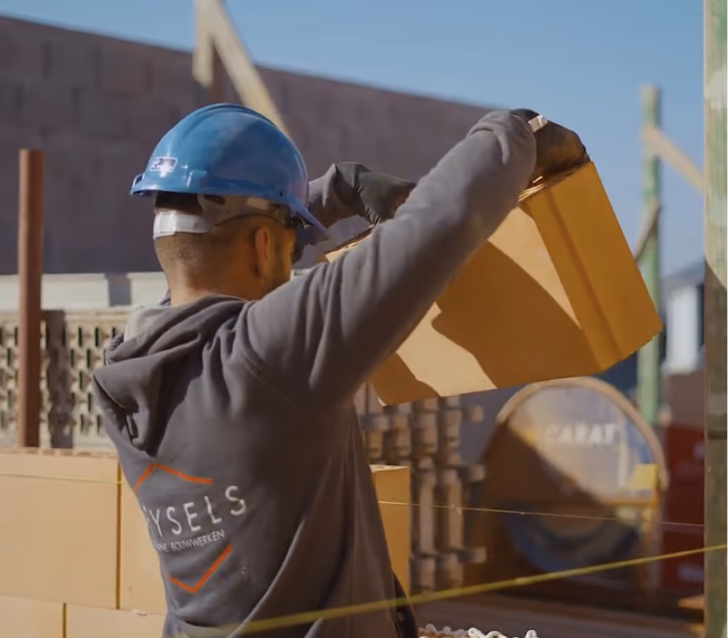 Vakman Bouwwerken Geysels met veiligheidshelm aan het werk op een nieuwbouwwerf