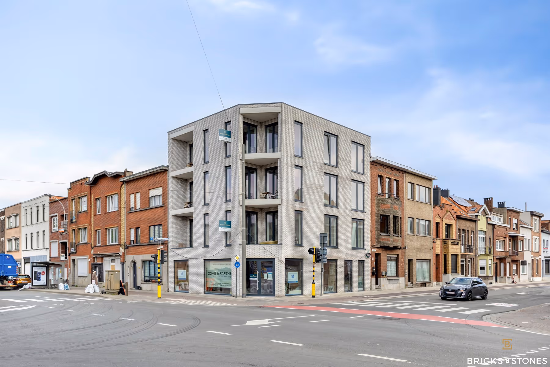 Modern hoekappartementsgebouw met lichte gevelsteen en zwarte raamprofielen — B2B-bouwproject