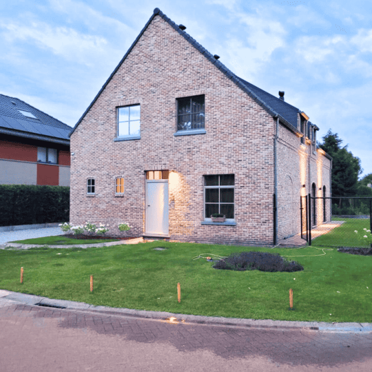 Moderne nieuwbouwwoning met traditioneel hellend dak en lichte bakstenen gevel in Weelde