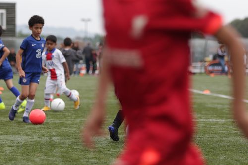 group of children playing football on a high quality pitch