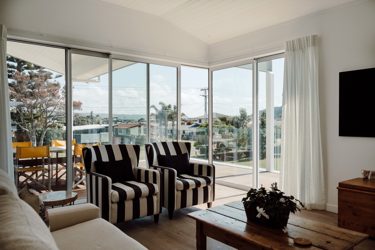 Living room with floor to ceiling glazing at 124 Diana Ave, Whangamatā