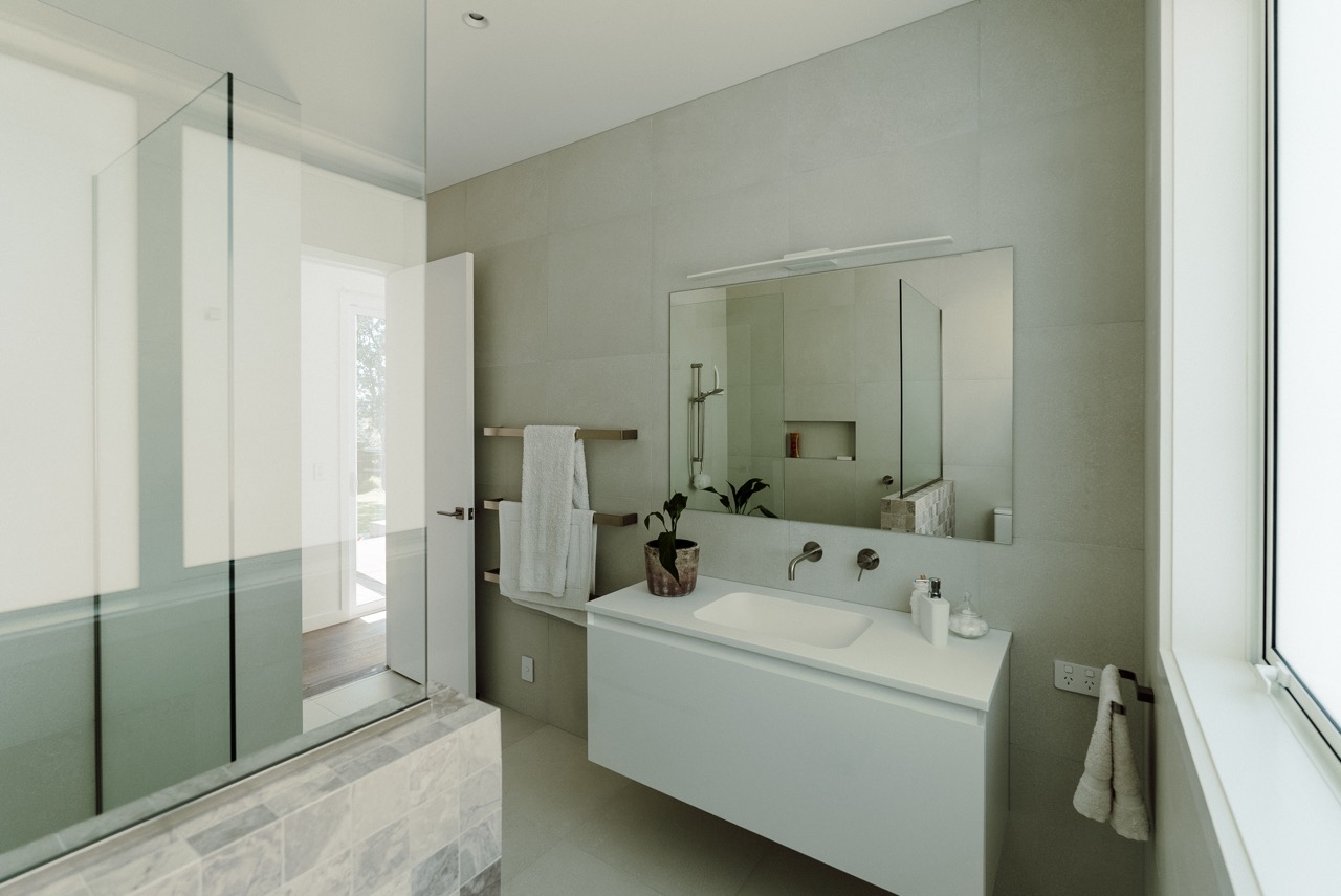 Bathroom with walk in shower and stone tiling at 124 Diana Ave, Whangamatā