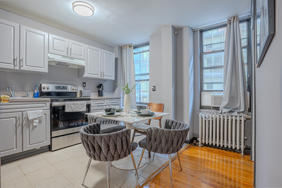A stylish kitchen with light gray cabinets, a cozy dining setup, and elegant decor.